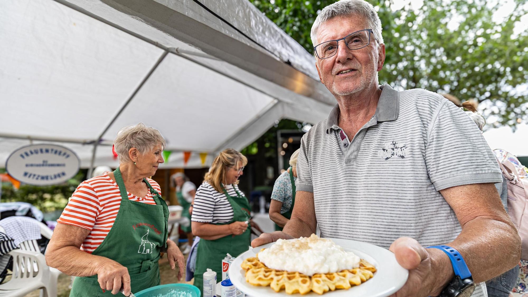 Ein Mann hält einen Teller mit einer Waffel und Reisbrei.