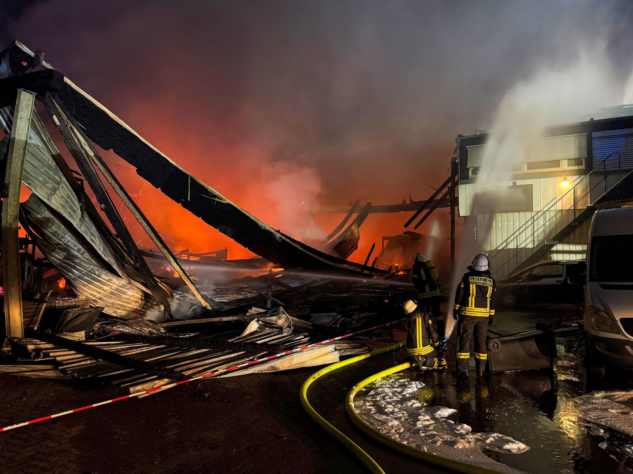 Feuerwehrkräfte sind mit Löscharbeiten beschäftigt.