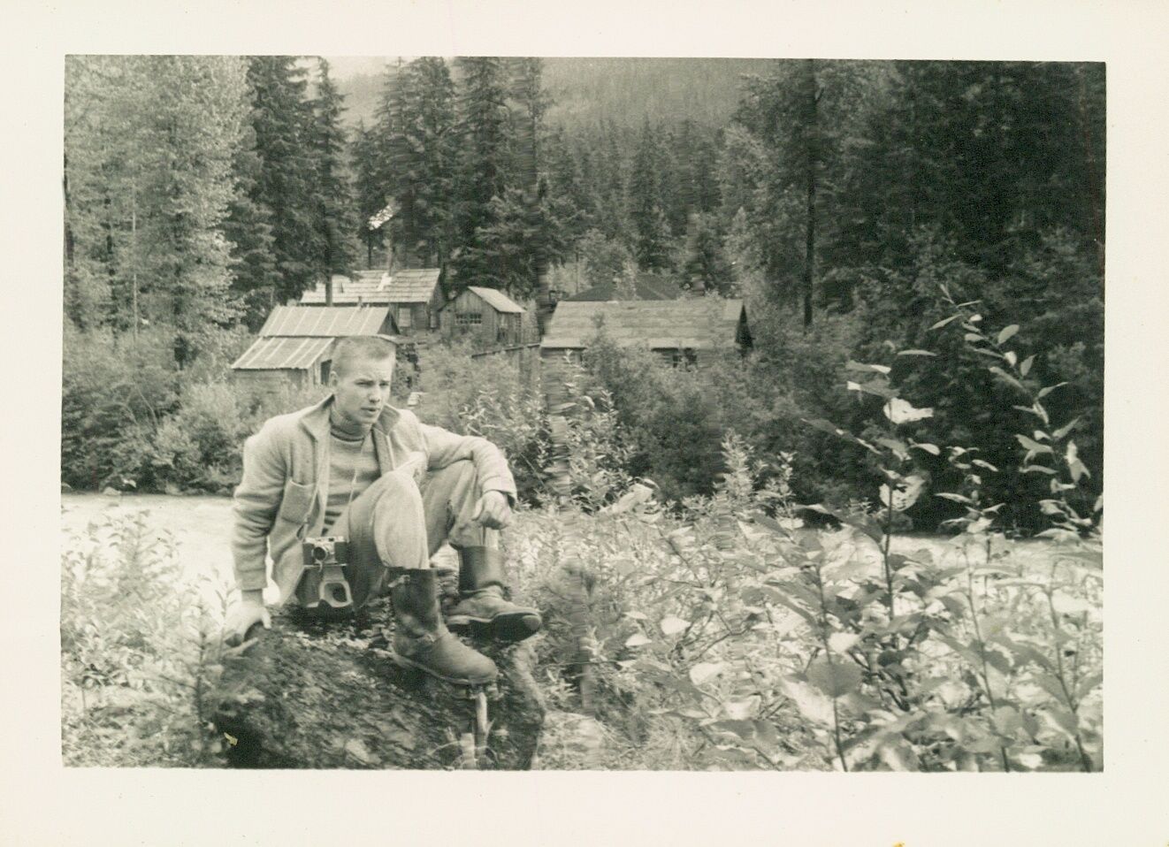 Schwarzweißbild eines jungen Mannes in wilder Landschaft.
