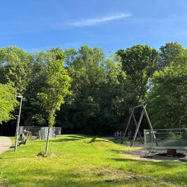 Spielgeräte auf dem Spielplatz sind umzäunt.