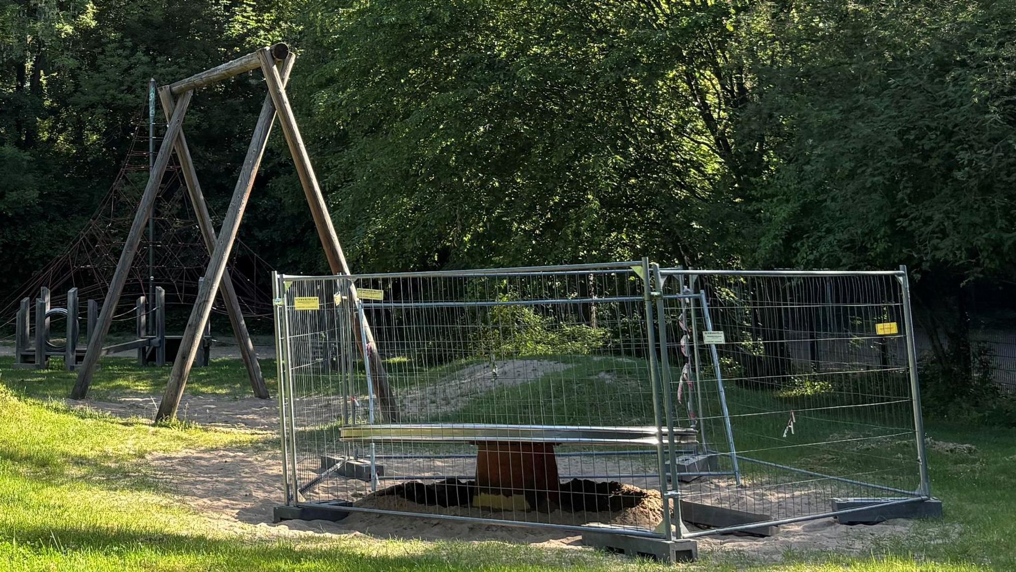 Spielgeräte auf dem Spielplatz sind umzäunt.