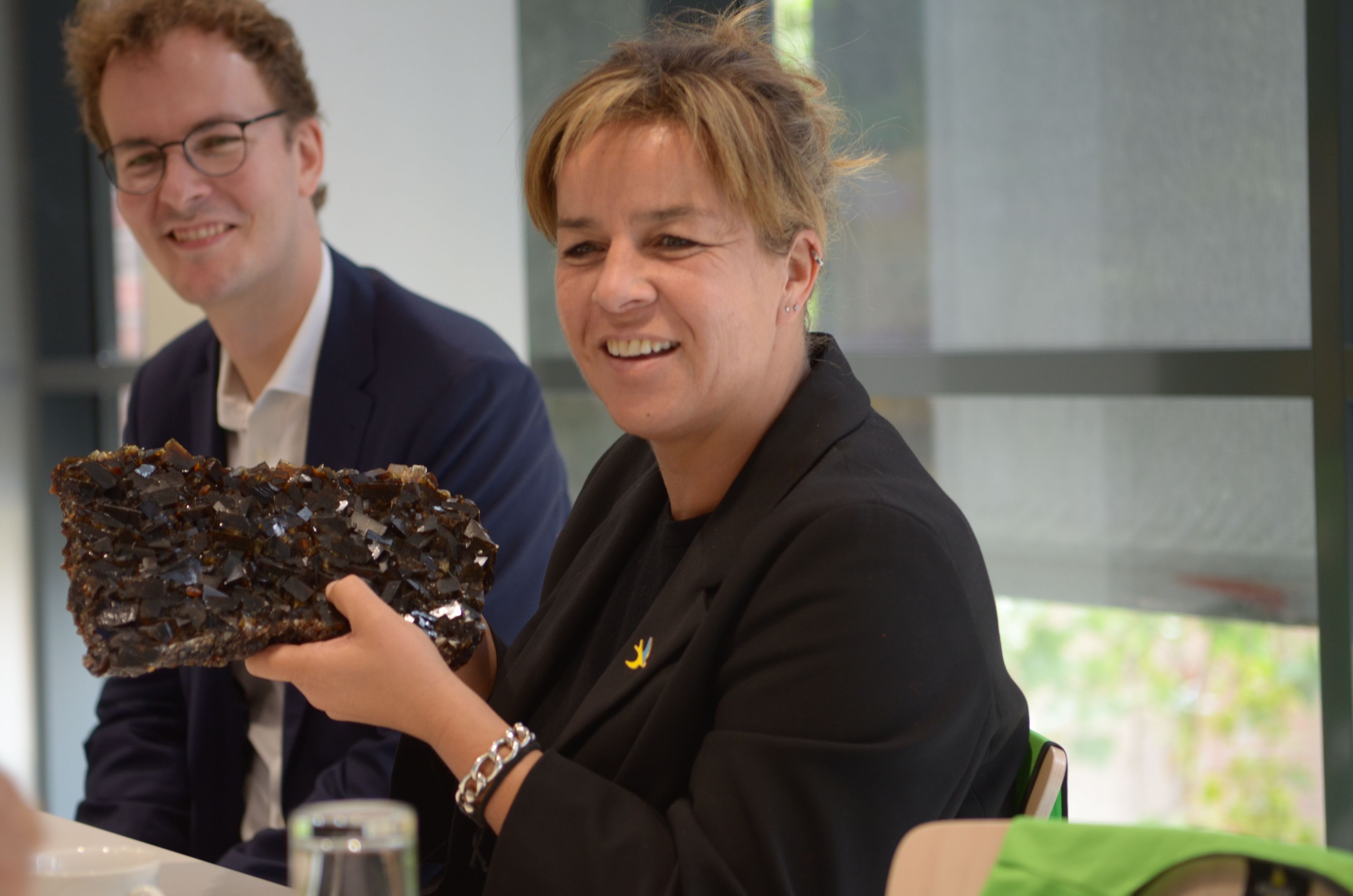 NRW-Wirtschaftsministerin Mona Neubaur hält beim Besuch der Firma Pfeifer & Langen in Euskirchen ein großes Stück Kandiszucker in den Händen.