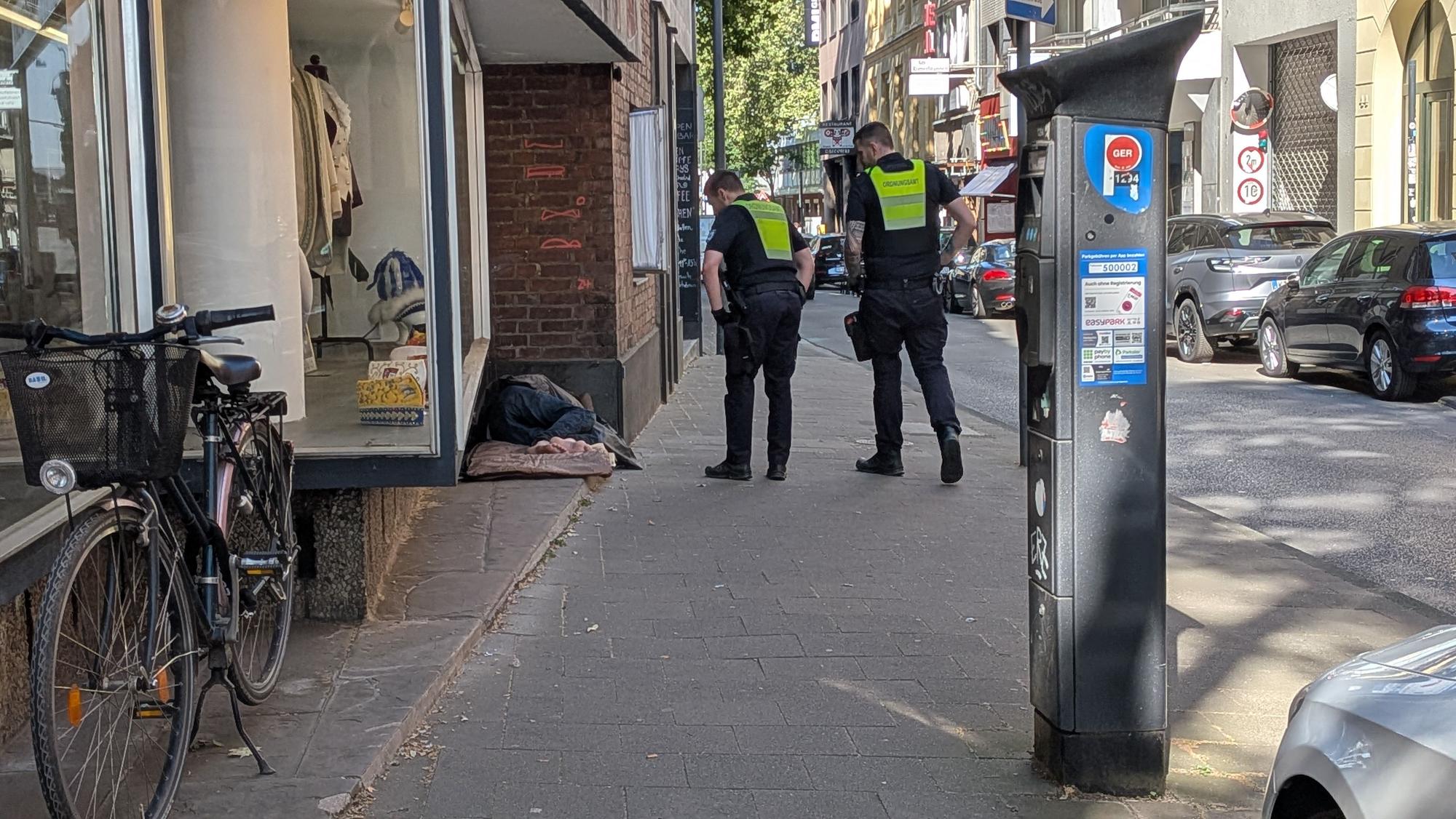 Mitarbeiter des Ordnungsamtes wecken einen Obdachlosen, der in der Nähe des Zeughauses geschlafen hat.