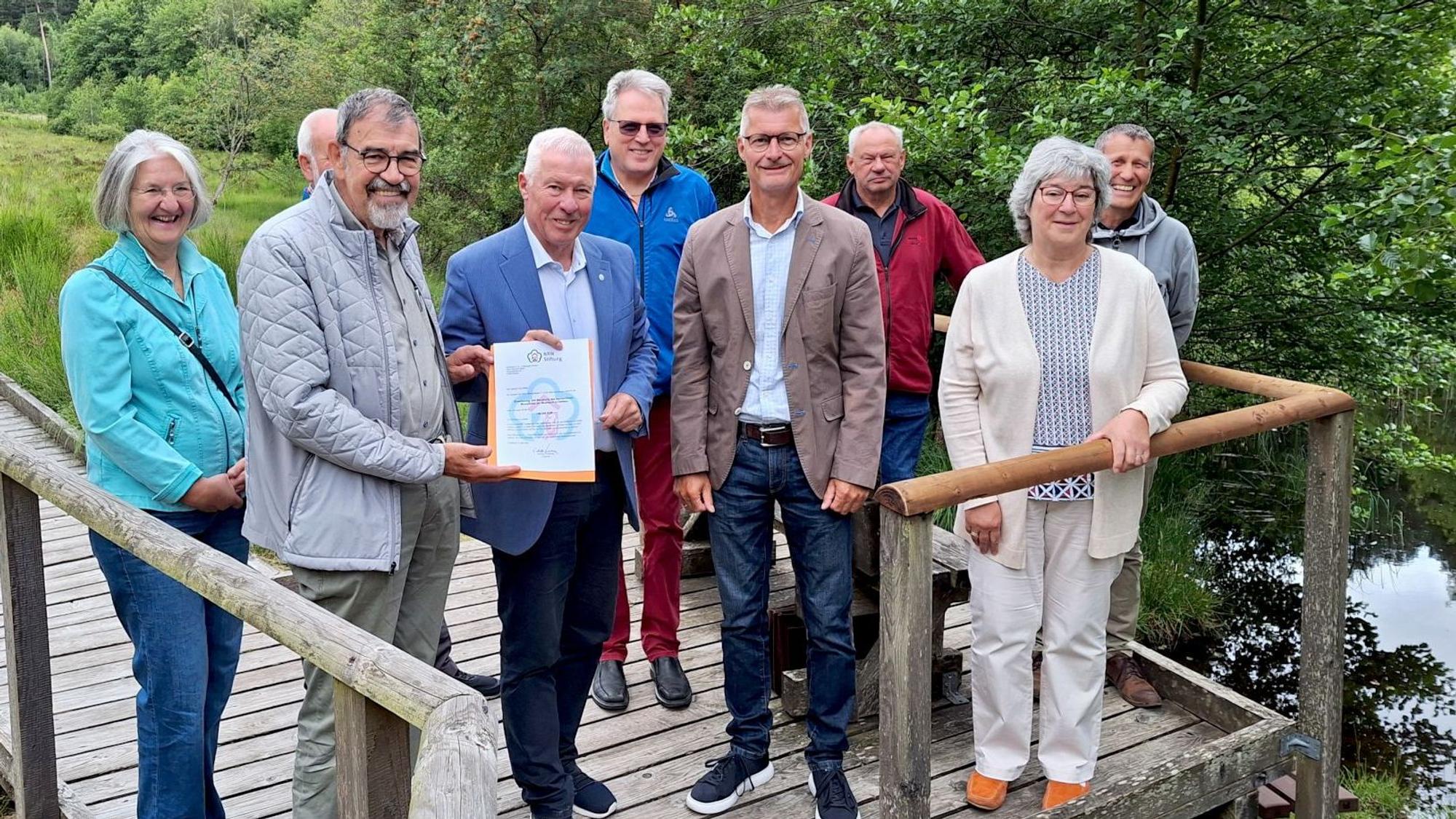 Eine Gruppe Männer und Frauen steht auf einer Plattform des Moorpfads in Dahlem.