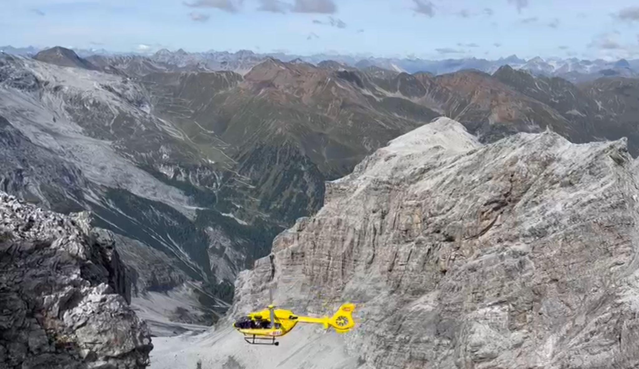 Ein Hubschrauber fliegt über ein Gebirge.