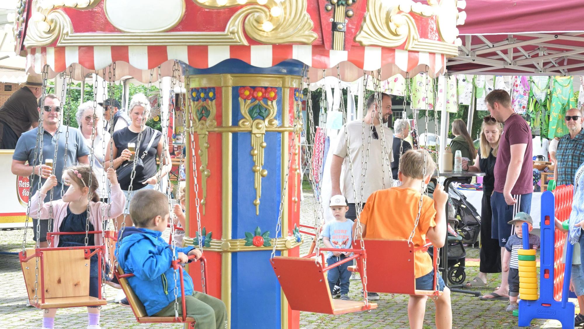 Zu sehen ist ein Kinderkarussell mit Kindern darin.
