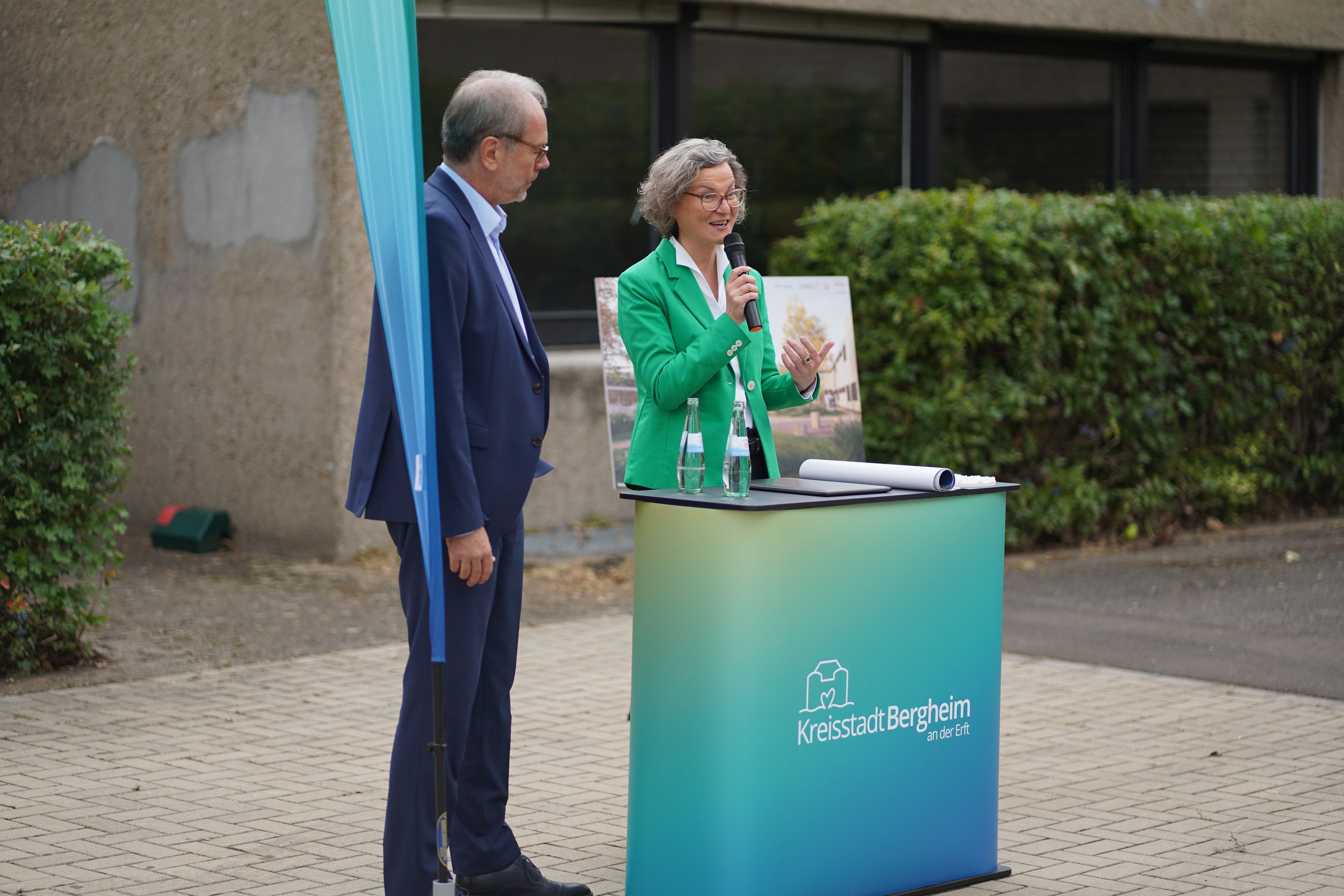 Das Foto zeigt eine Frau, die in ein Mikrofon spricht.