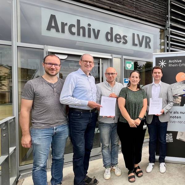 Frauen und Männer haben sich am Eingang des LVR-Archivs fürs Foto aufgestellt.
