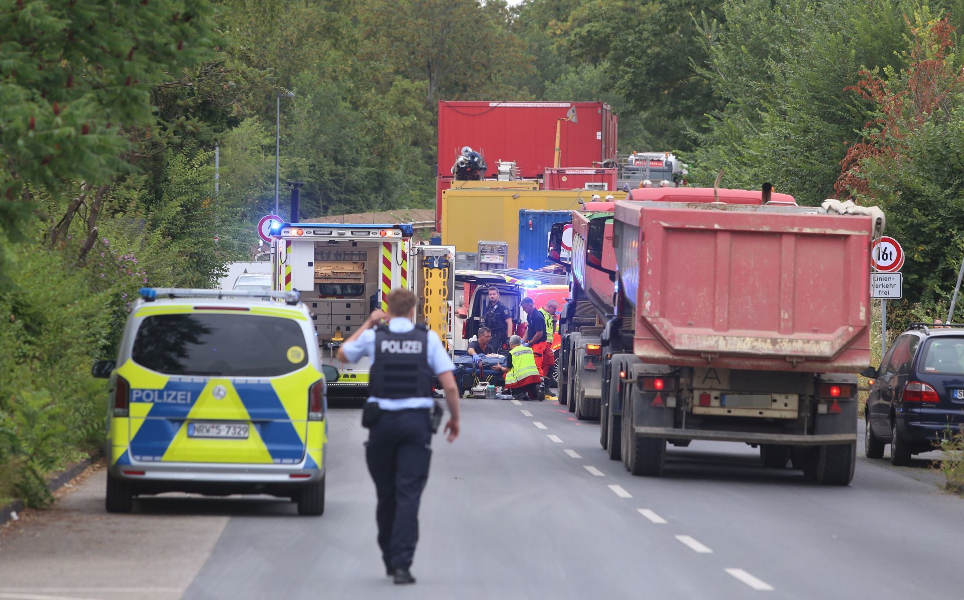 Mehrere Lastwagen neben einem Polizeifahrzeug und einem Rettungswagen.