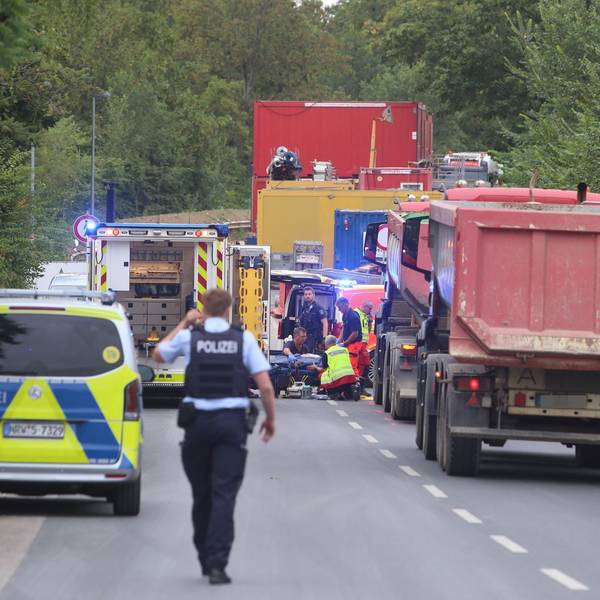 Mehrere Lastwagen neben einem Polizeifahrzeug und einem Rettungswagen.