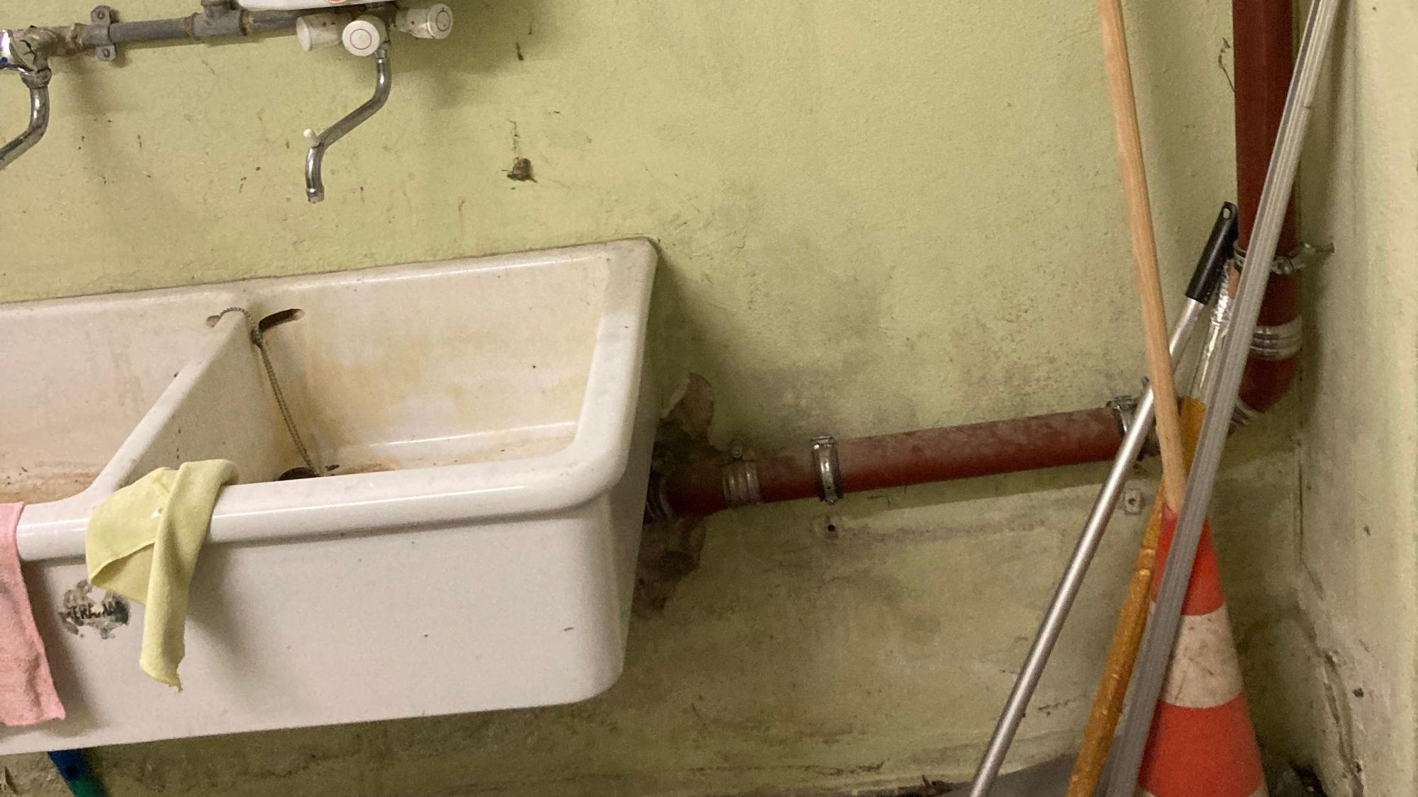 Neben einem Waschbecken befinden sich Schimmelflecken an der Wand.
