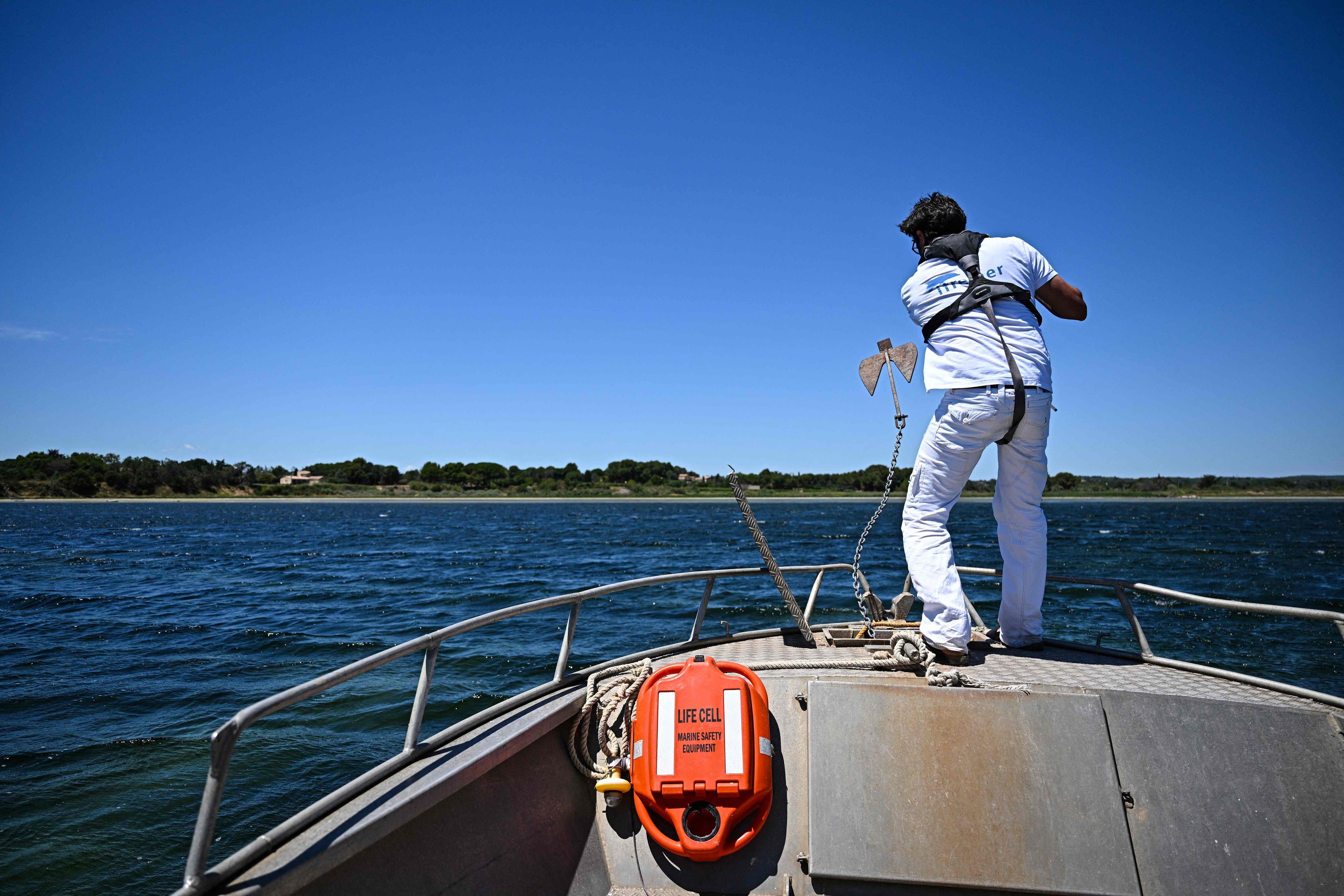 Ein Wissenschaftler lässt den Anker eines Forschungsbootes ins Wasser, bevor er die Gewässer des Étang de Thau bei Sète in Südfrankreich untersucht.