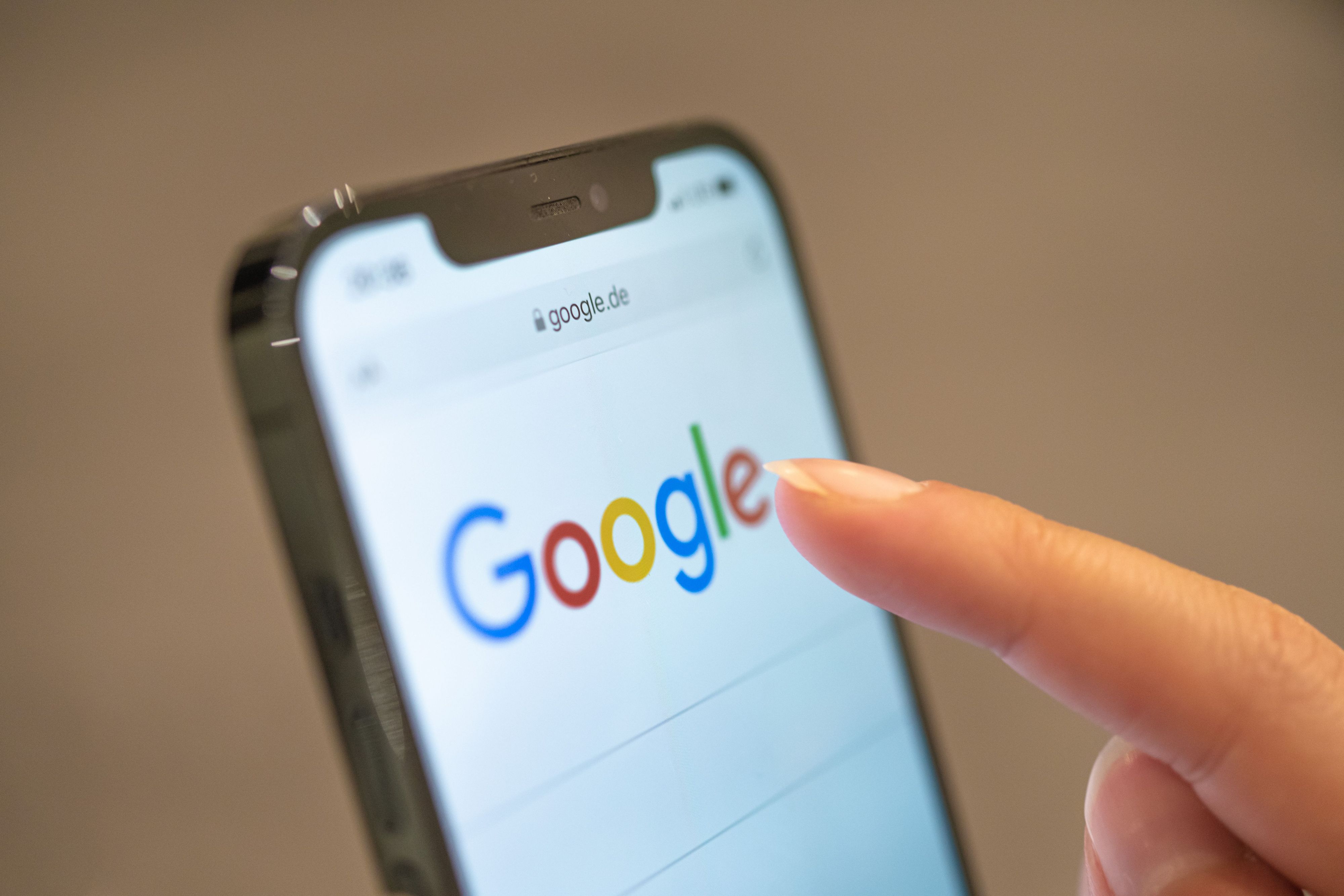 Eine Frau hält ihr Handy in der Hand, auf dem die Google-Seite im Browser zu sehen ist. (Symbolbild)