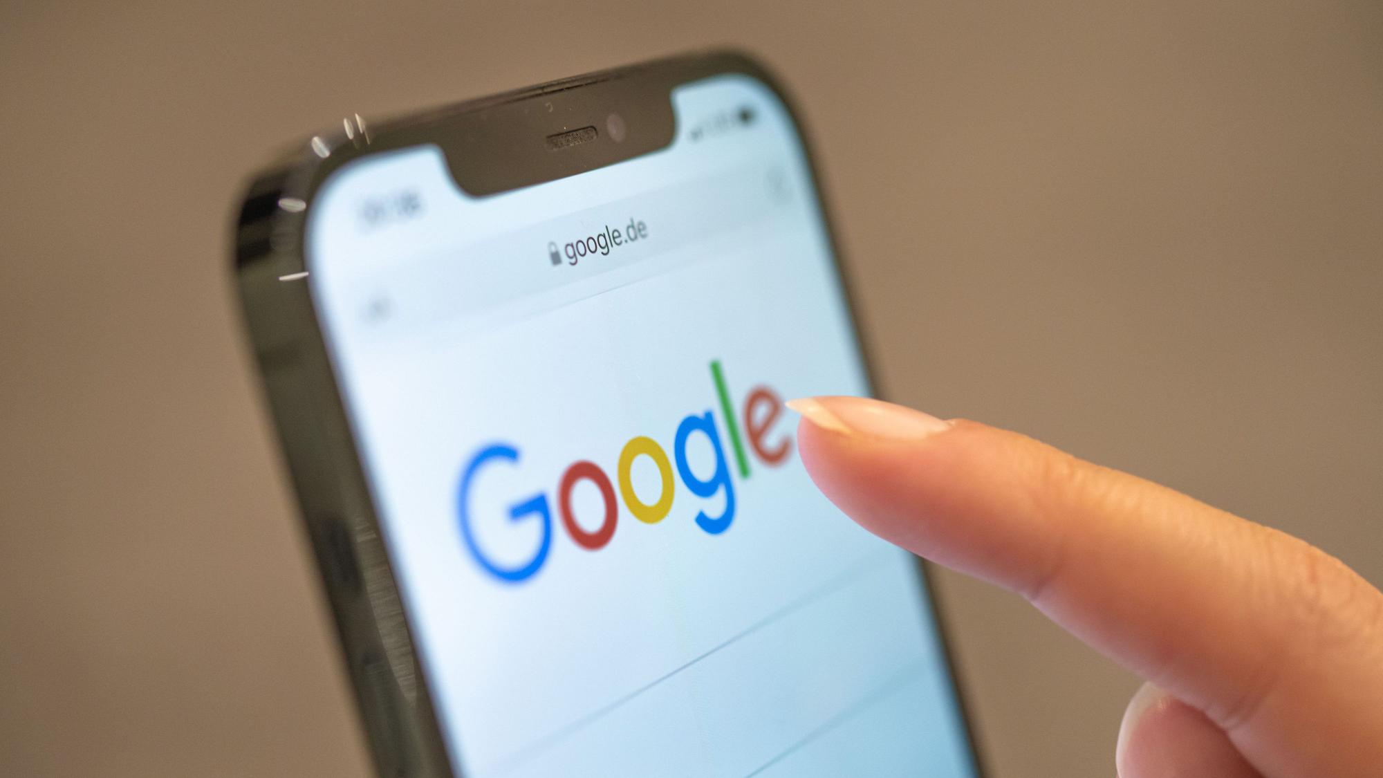 Eine Frau hält ihr Handy in der Hand, auf dem die Google-Seite im Browser zu sehen ist. (Symbolbild)