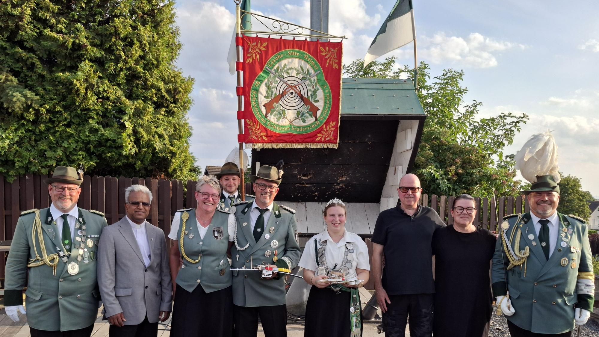Schützen mit und ohne Uniform haben sich zum Gruppenbild aufgestellt.