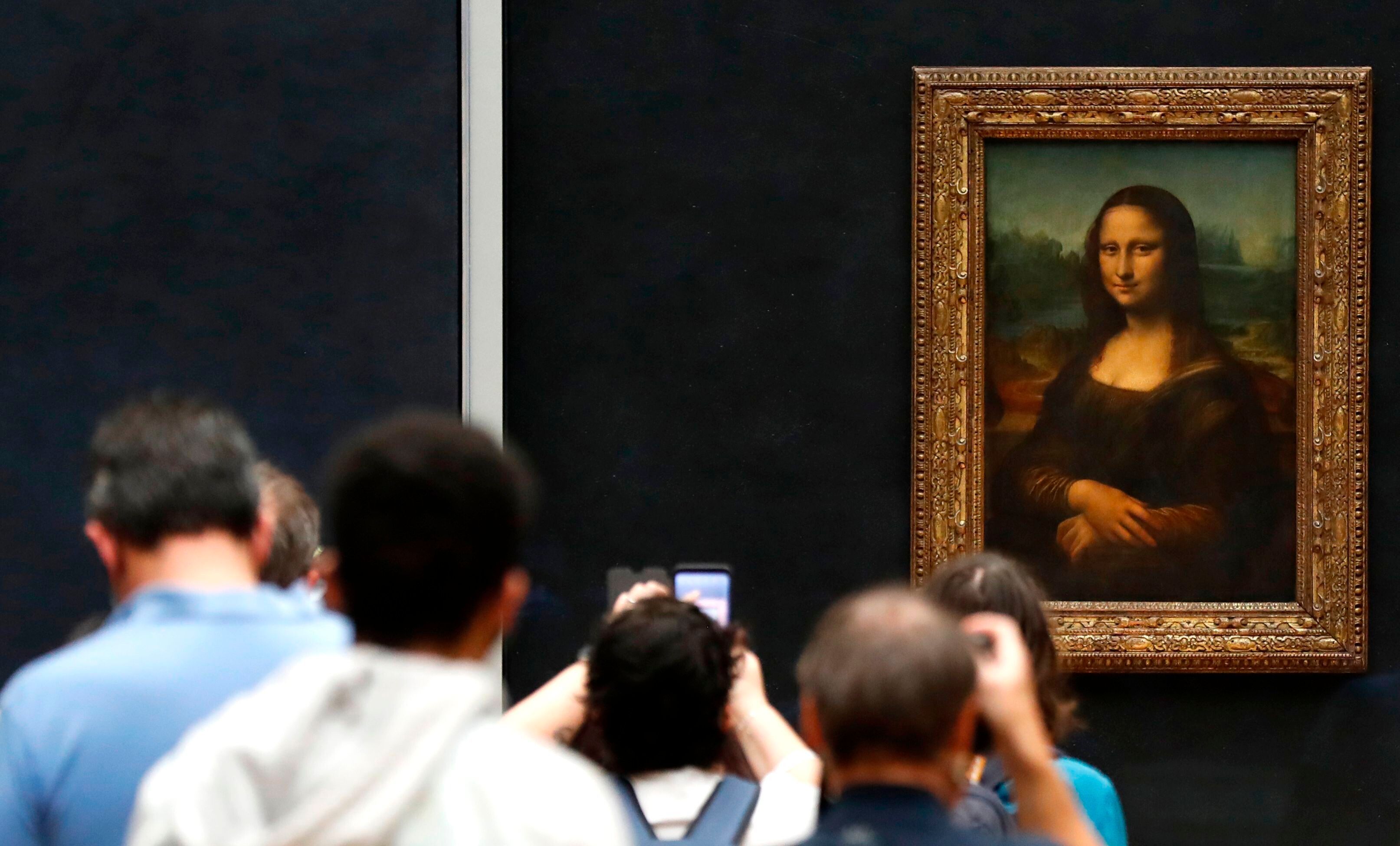 Besucher machen Fotos vor Leonardo da Vincis Meisterwerk "Mona Lisa" im Louvre-Museum.