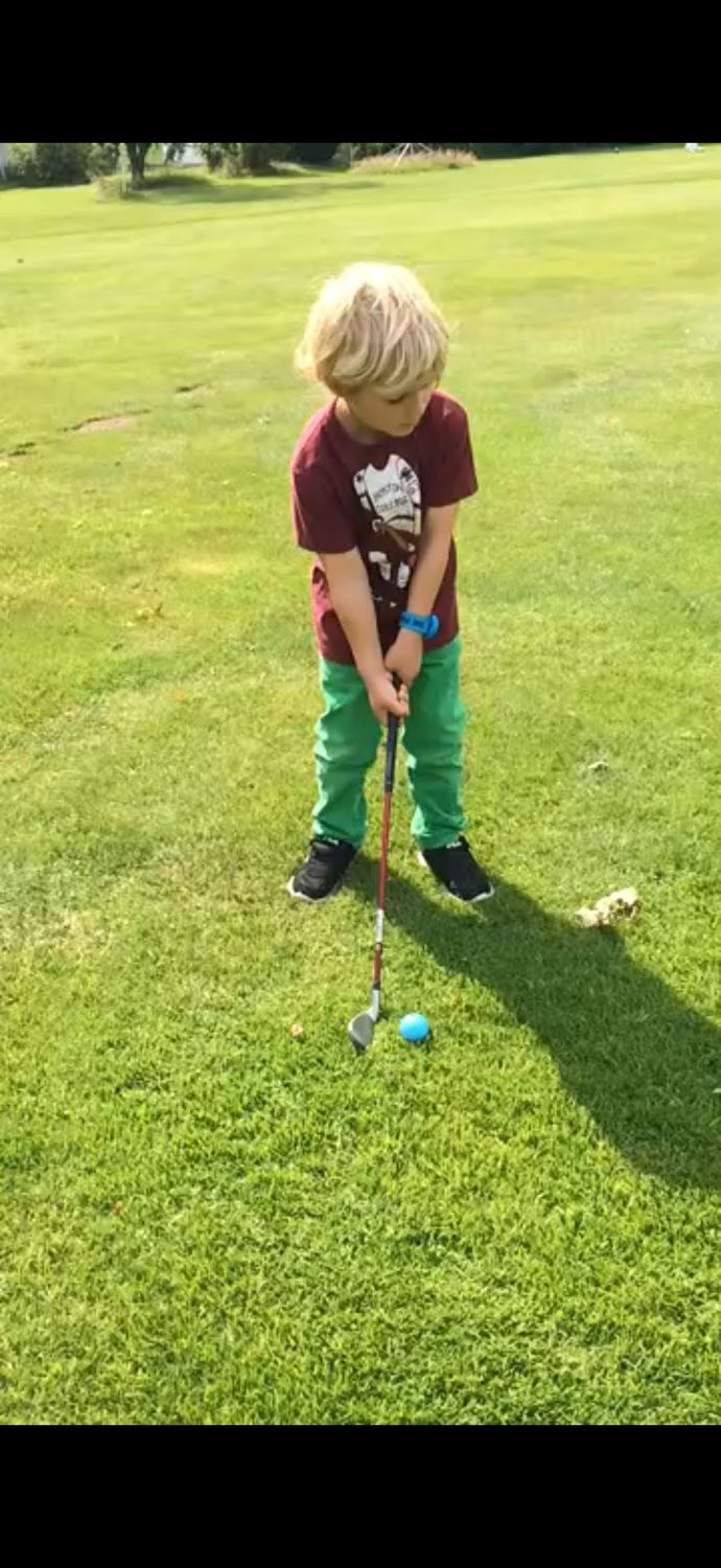 Der kleine Junge beim Abschlag.