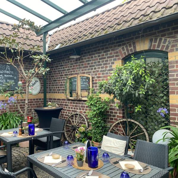 Zwischen historischen Backsteinmauern genießen Gäste im Innenhof des Ristorante Remise italienische Spezialitäten in besonderem Ambiente.