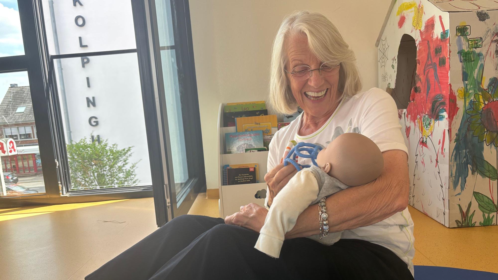 Das Foto zeigt eine Frau, die ein Baby auf dem Arm hält.
