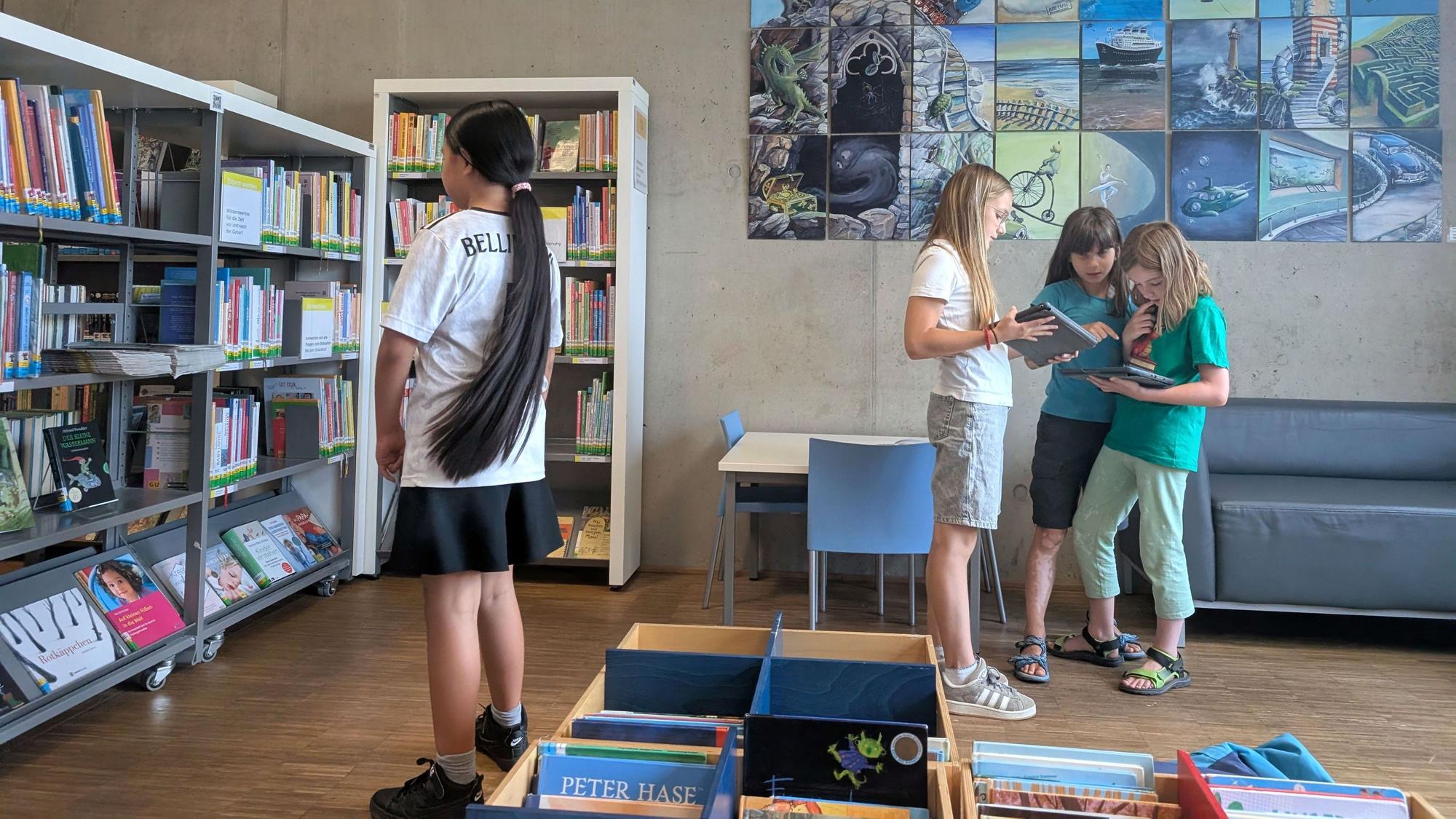 Das Bild zeigt einen Blick in die Stadtbibliothek Euskirchen. Kinder schauen in ein Buch.