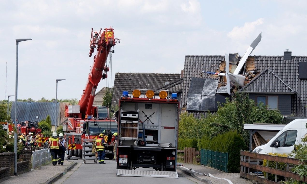 Ein abgestürztes Leichtflugzeug steckt im Dach eines Hauses. Beim Absturz des Flugzeugs in ein Einfamilienhaus ist mindestens ein Mensch ums Leben gekommen.