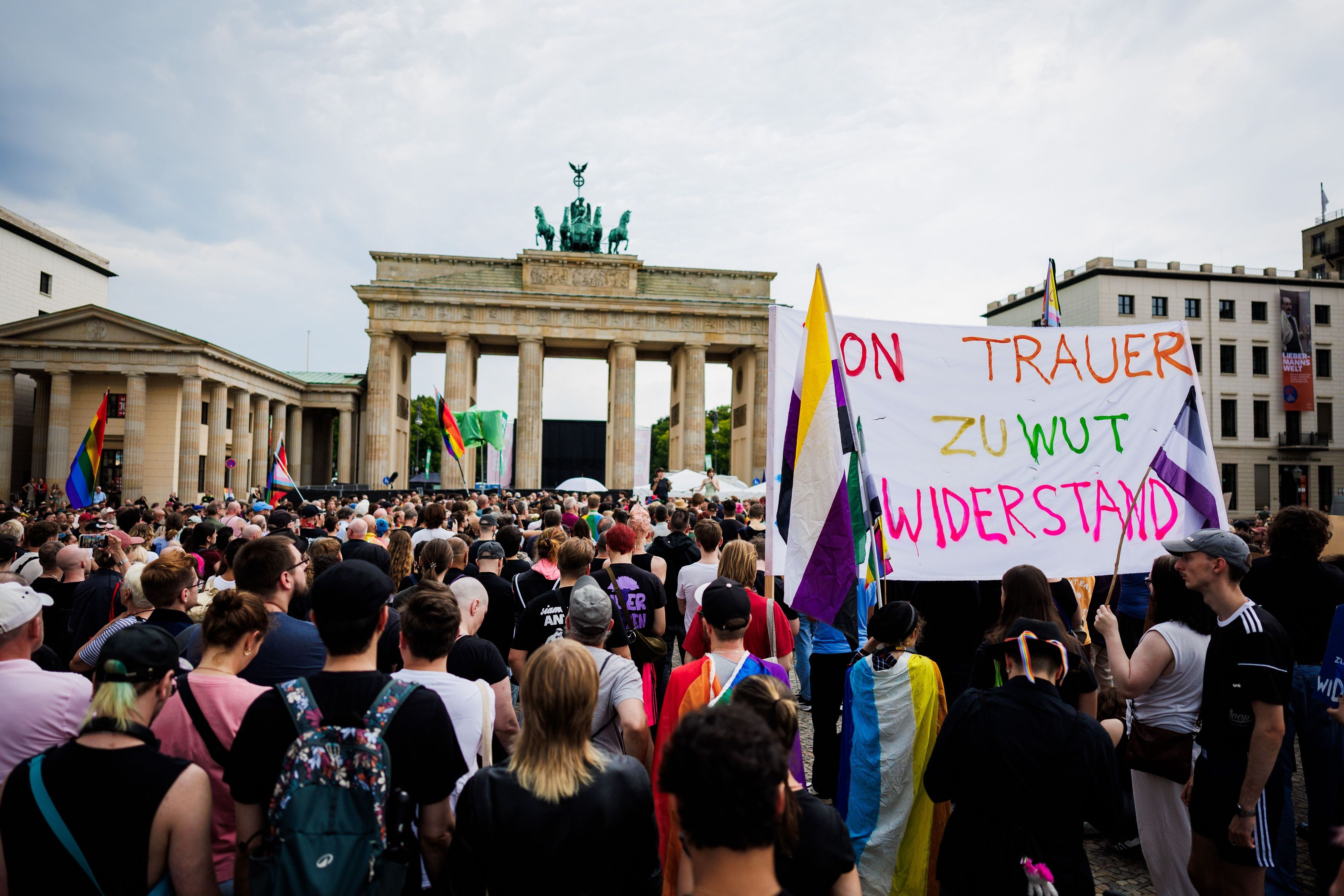Menschen trauern und demonstrieren vor dem Brandenburger Tor. Dabei wird ein Transparent mit der Aufschrift „Von Trauer zu Wut Widerstand!“ gehalten.