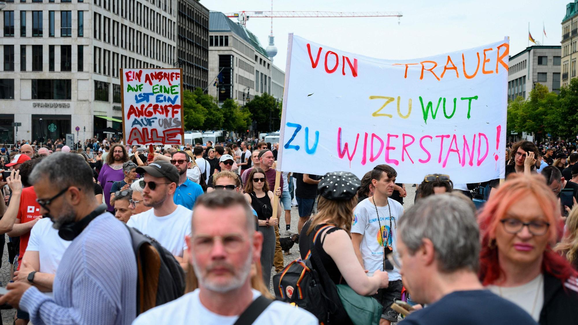 Menschen demonstrieren am Brandenburger Tor nach dem Anschlag auf den Berliner CSD.