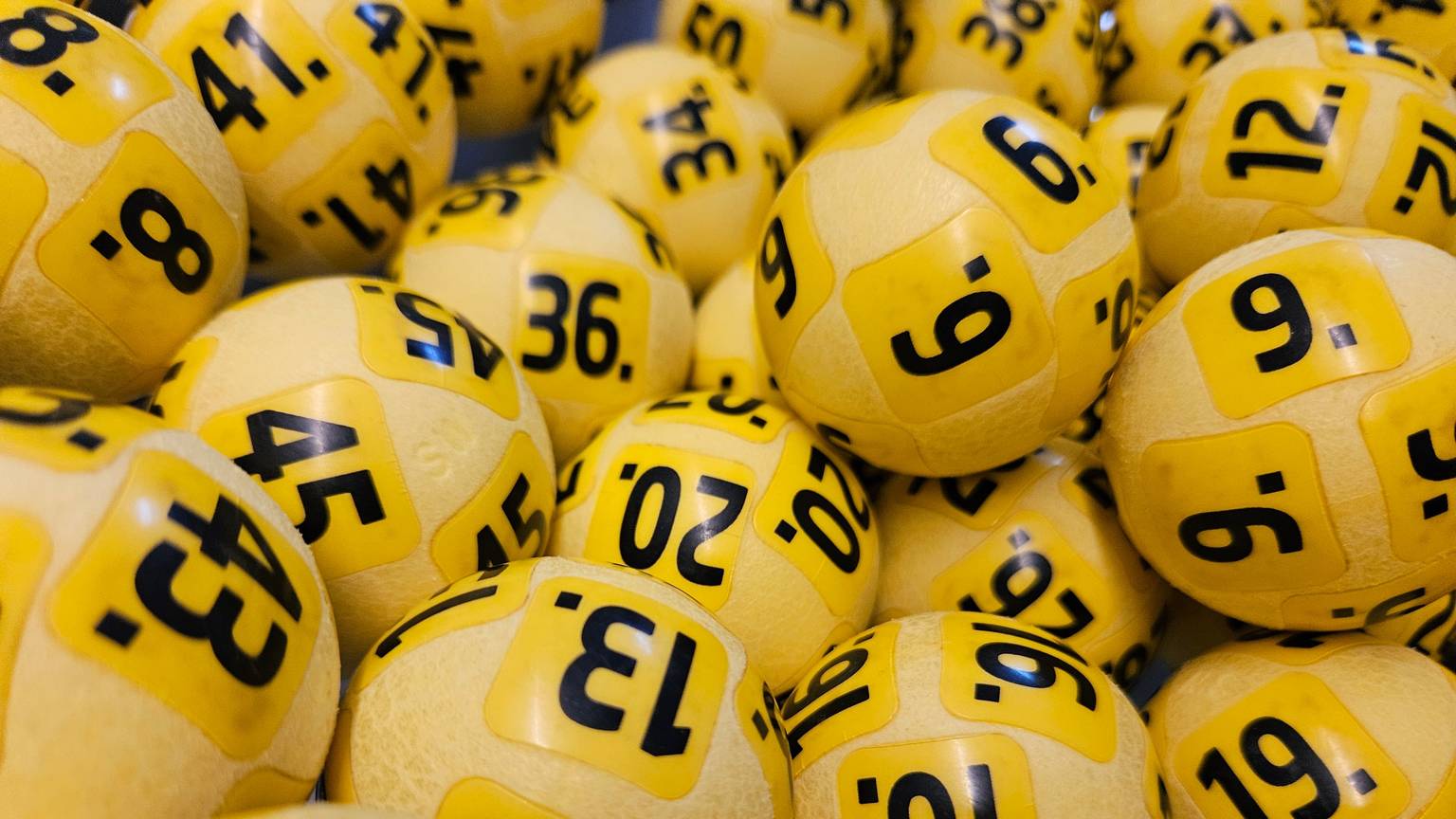 Nahaufnahme von gelben Eurojackpot-Kugeln mit schwarzen Zahlen.