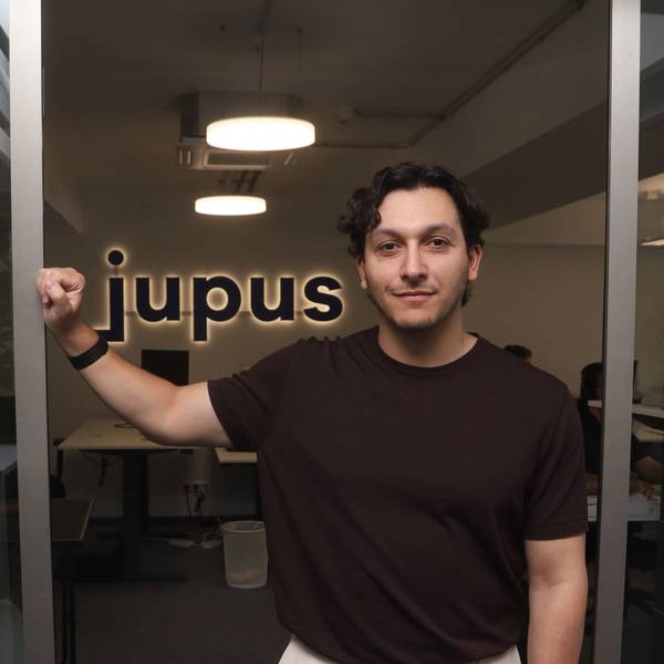 René Fergen steht im Büro vor einem Schriftzug des Unternehmens Jupus