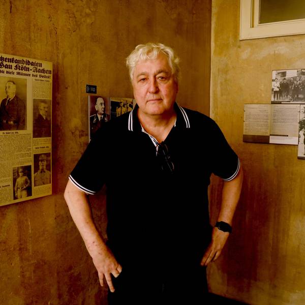 Der Journalist Axel Spilcker zu Besuch im NS-Dokumentationszentrum in Köln. An der Wand der Ausstellung hängt ein Artikel aus der NS-Zeit mit einem Foto seines Großvaters Robert Ley.