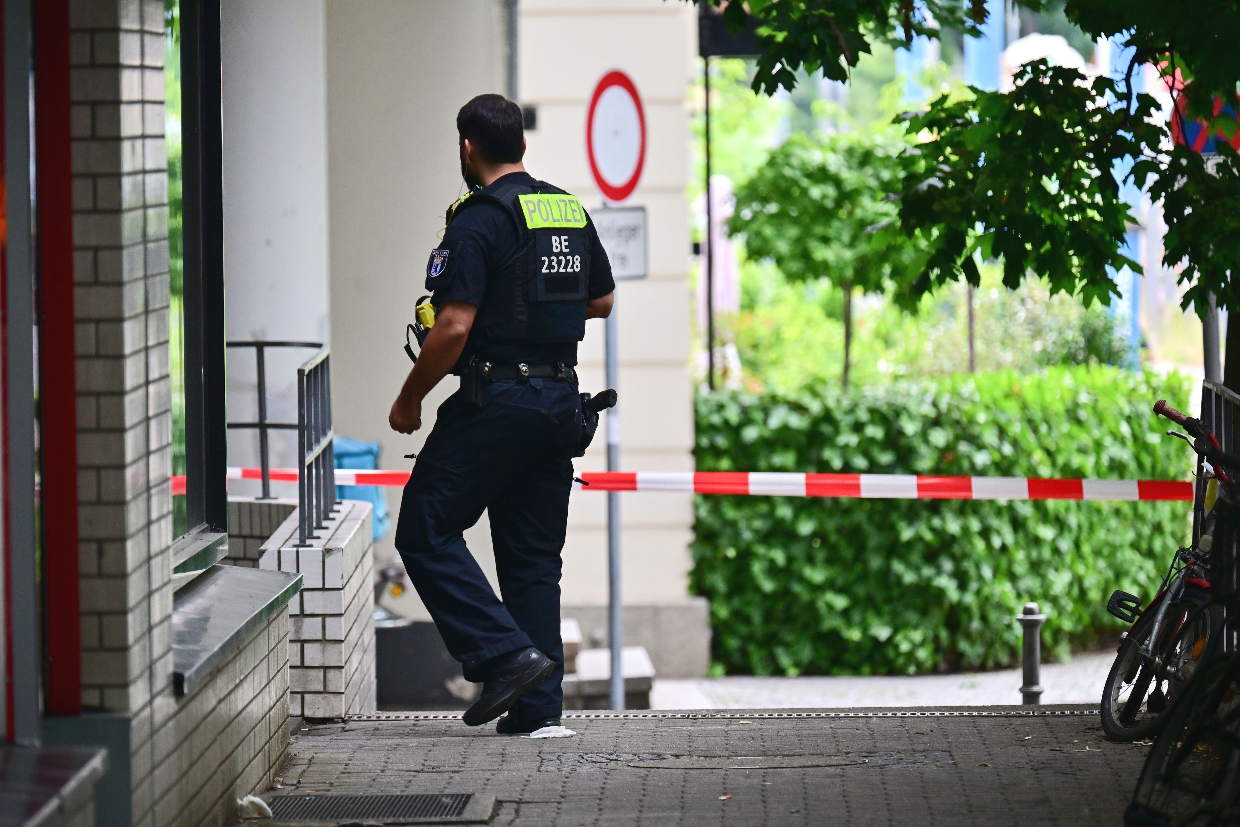 Ein Polizeibeamter geht an den Wohnblöcken vorbei, in denen in der Nacht eine Wohnung durchsucht wurde. Am Rande des Christopher Street Day in Berlin war das Fahrzeug in eine Menschenmenge gefahren.