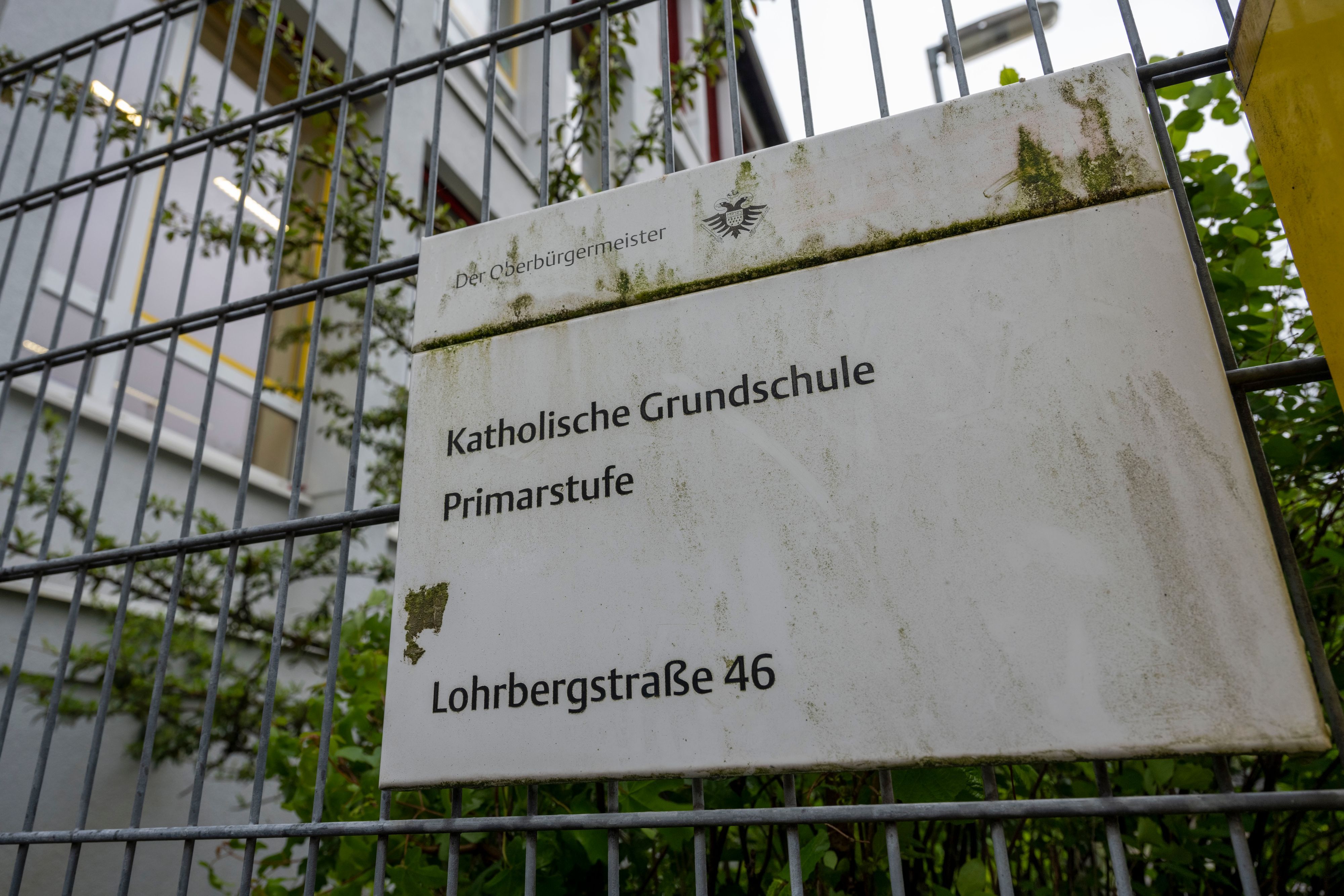 Ein Schild an einem Gitter weist auf die Grundschule Lohrbergstraße in Klettenberg hin.