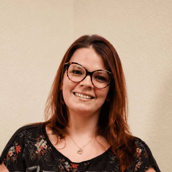 Das Bild zeigt Sandra Cornely. Sie lächelt, trägt eine Brille und hat lange, braune Haare.