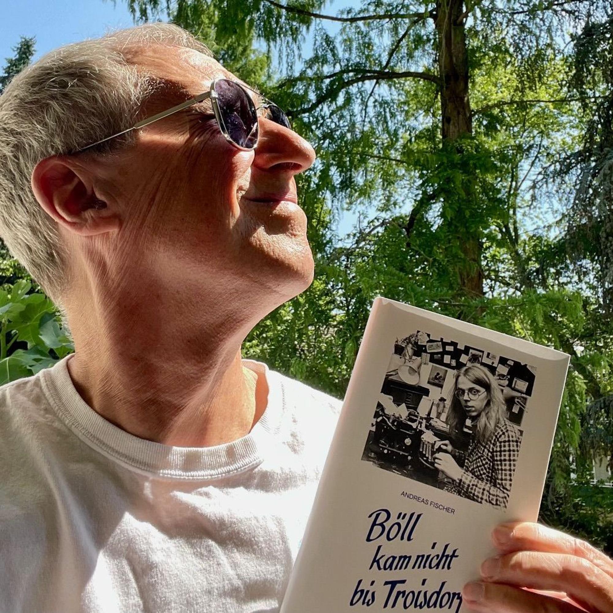 Martin Oehlen mit Buch im Grünen