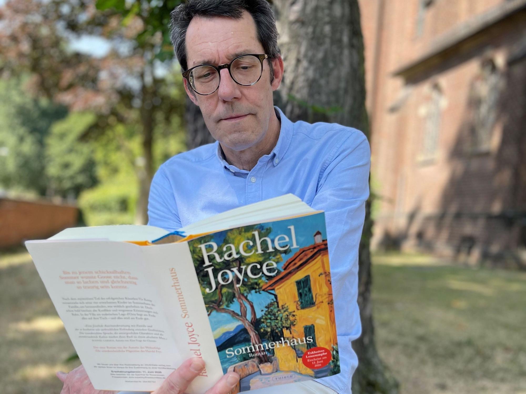 Jens Bartsch mit Buch unter einem Baum