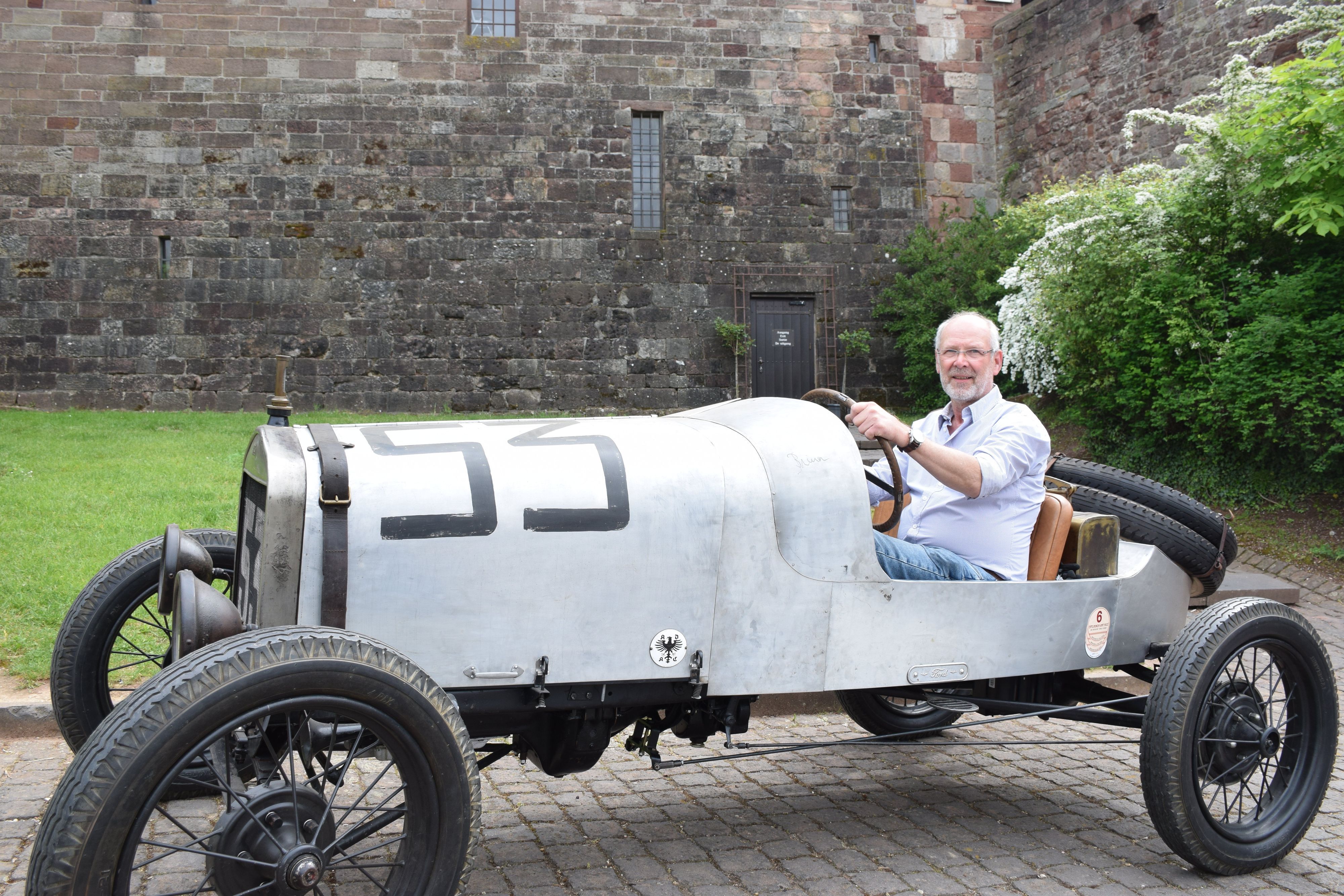 Georg Becker sitzt am Steuer seines Nachbaus des Fords von Gustav Münz mit der Startnummer 53.