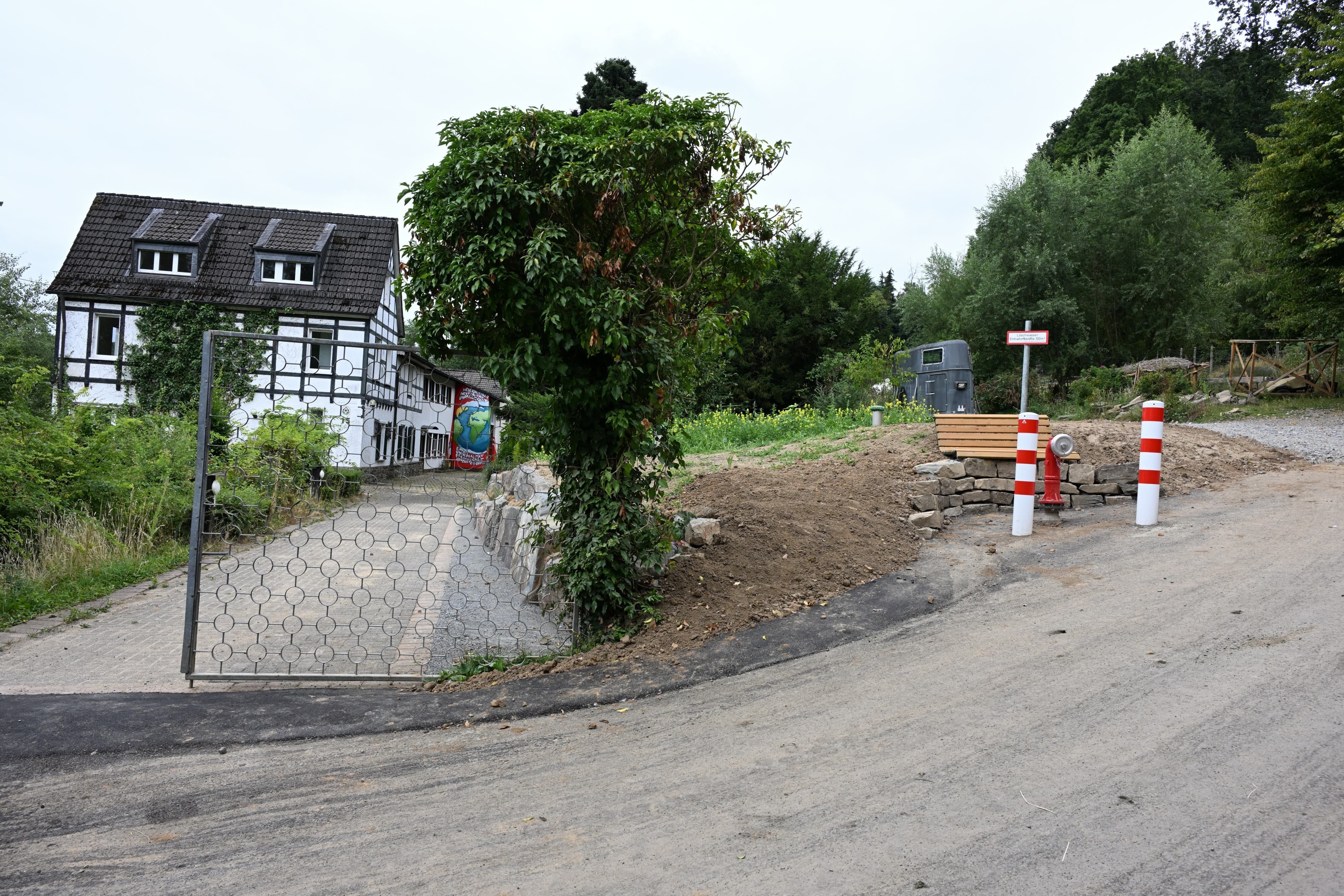 Von der Straße zweigt die Zufahrt zu einem Gebäude ab.