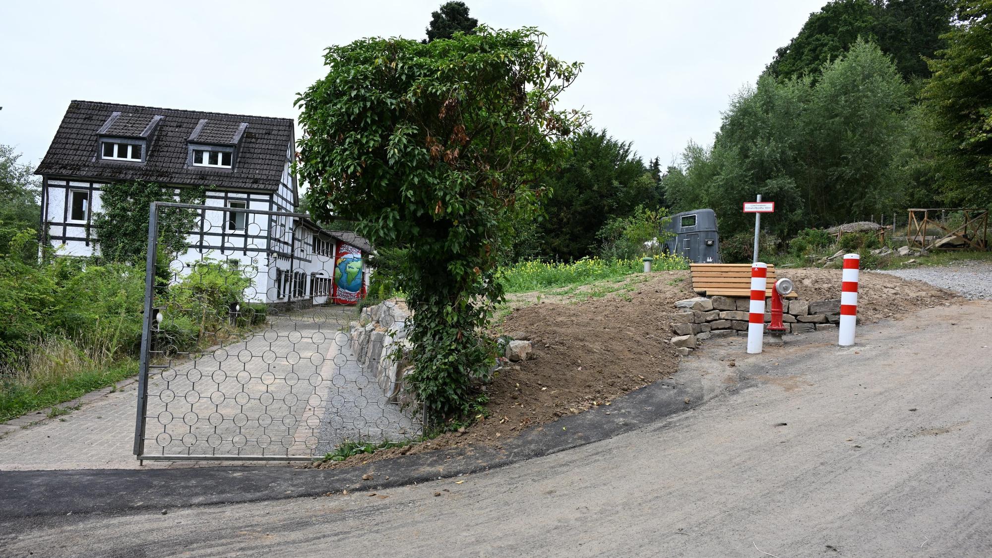 Von der Straße zweigt die Zufahrt zu einem Gebäude ab.