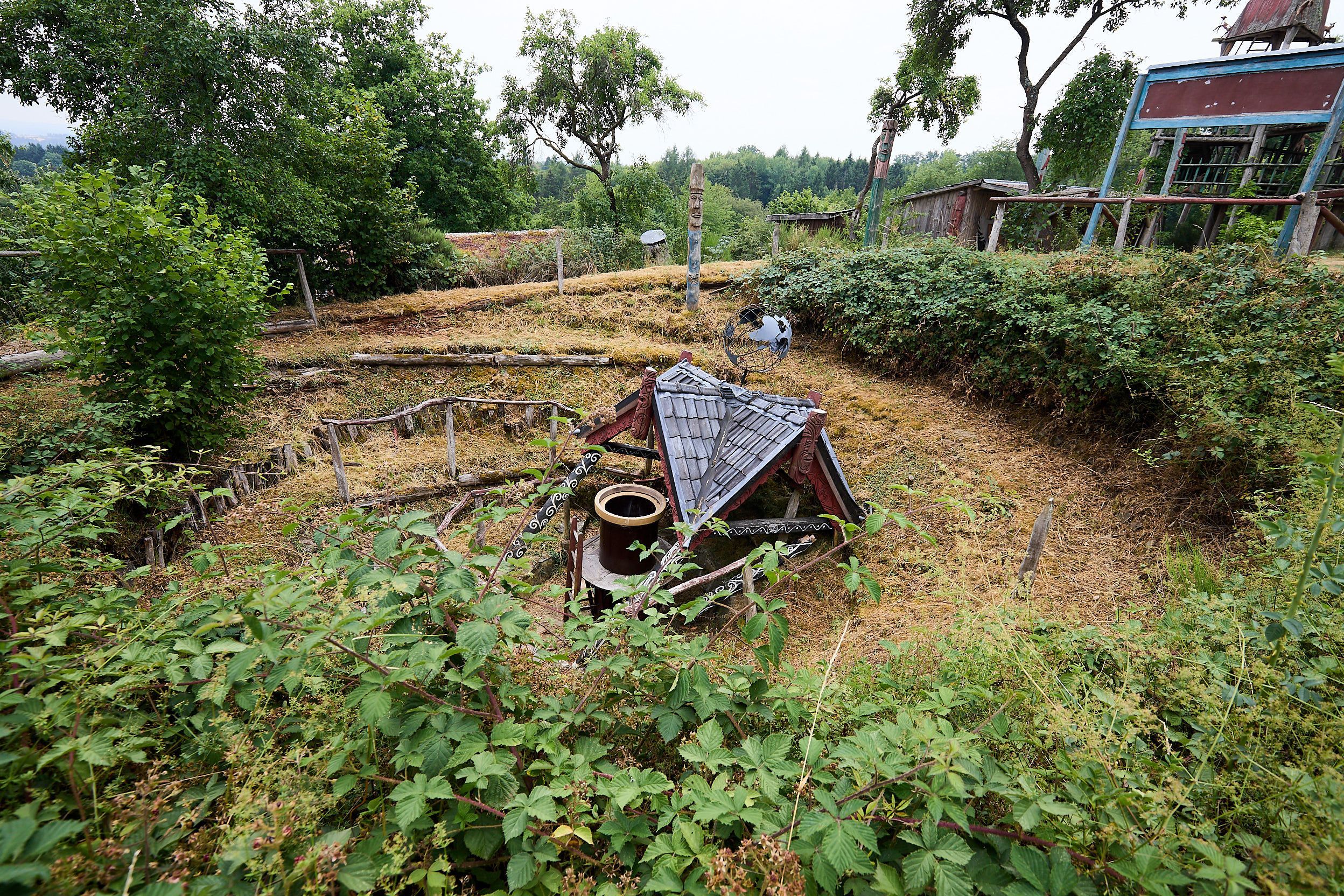 Das zusammengefallen Maorihaus. Darum windet sichdie Erdspirale.