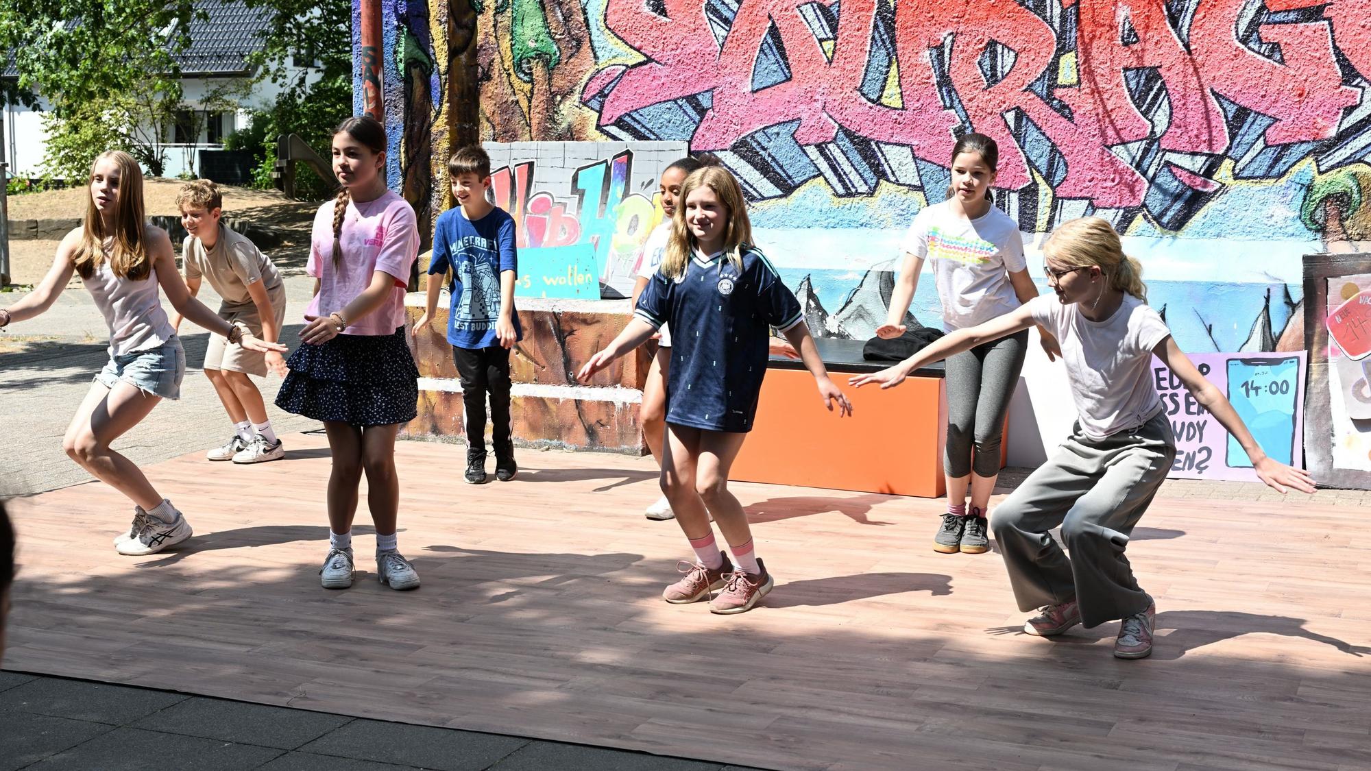 Eine gruppe Kinder tanzt auf einer Bühne.