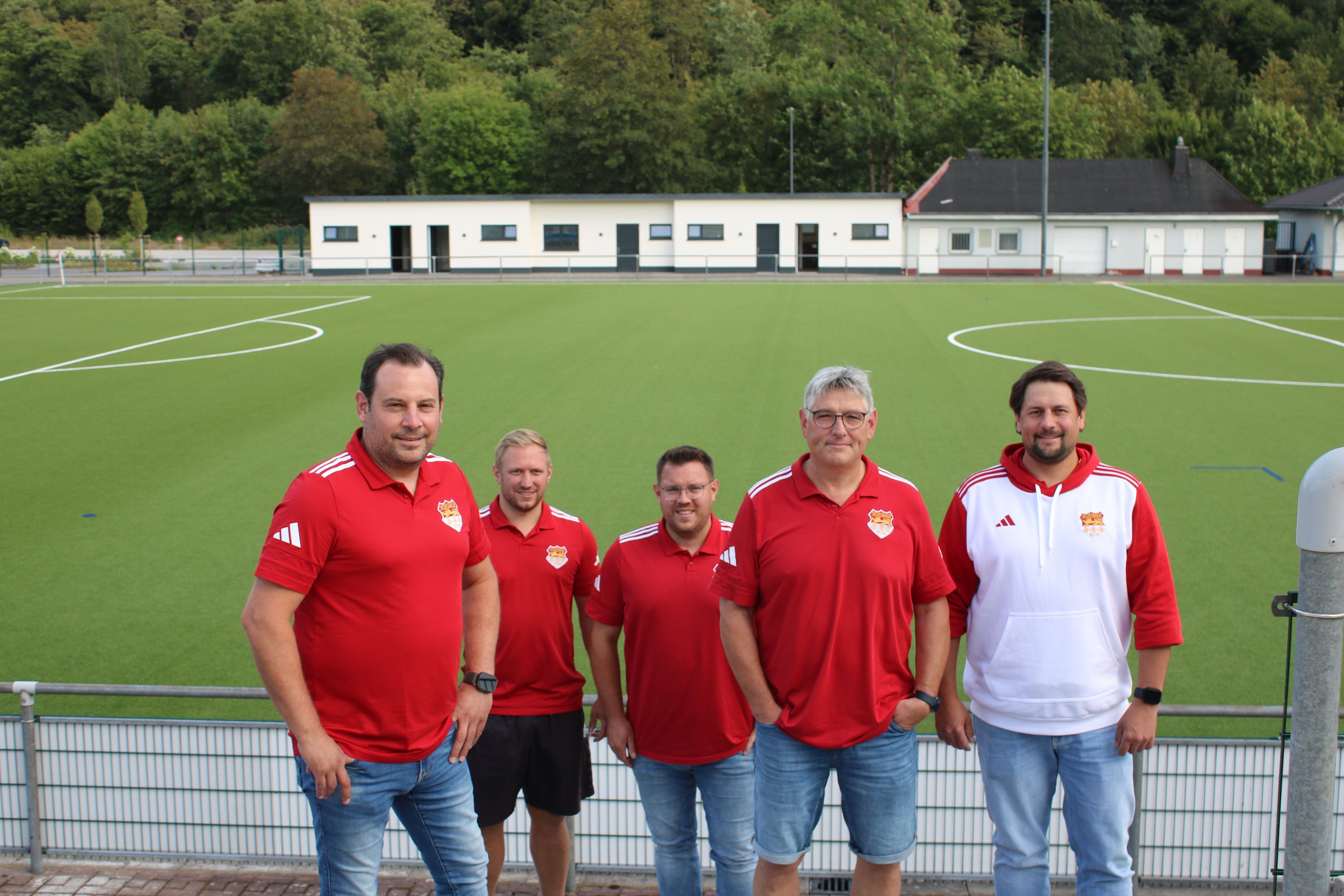 Gruppenfoto vor dem frisch sanierten Sportplatz.