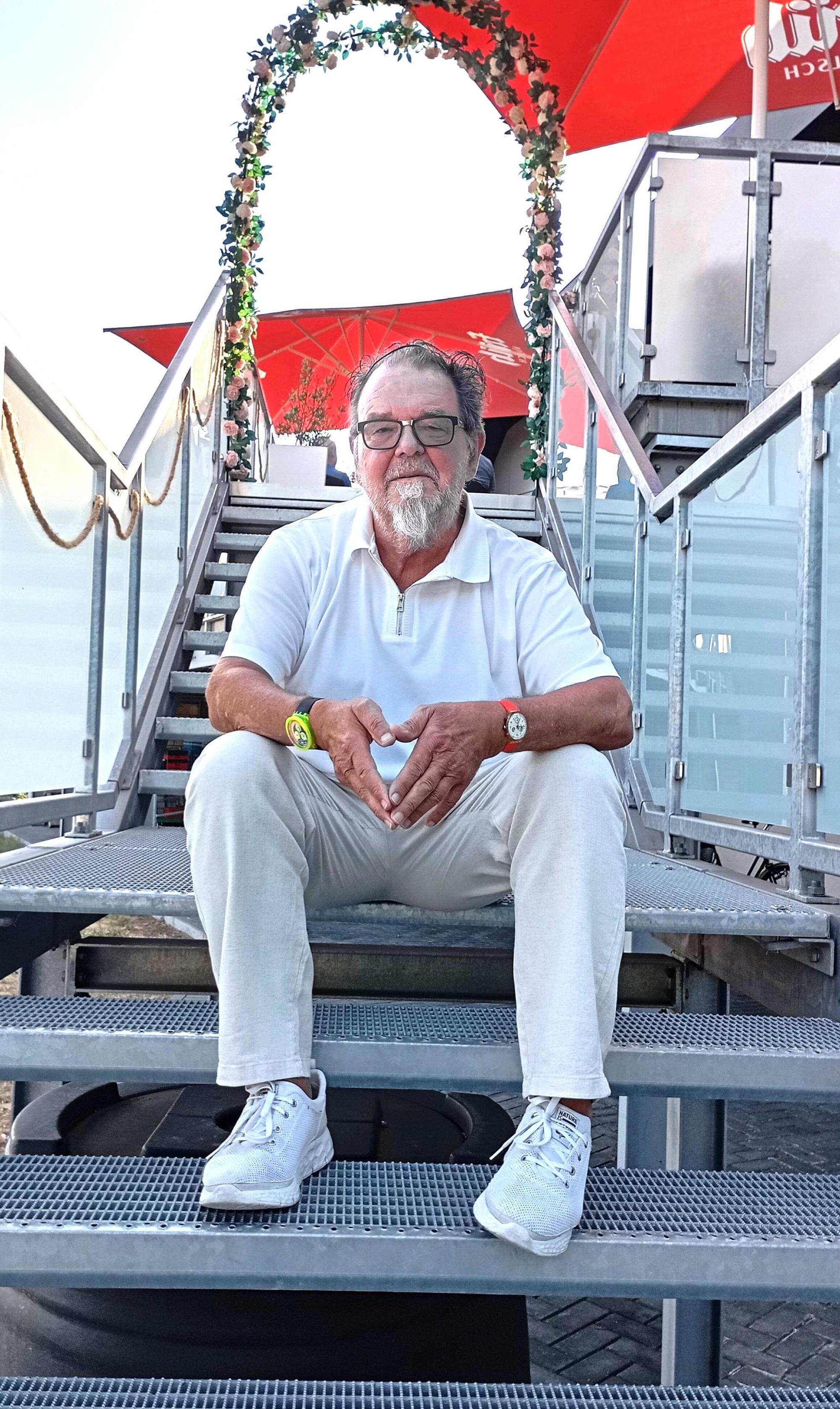 Das Foto zeigt einen Mann, der auf einer Treppe sitzt.