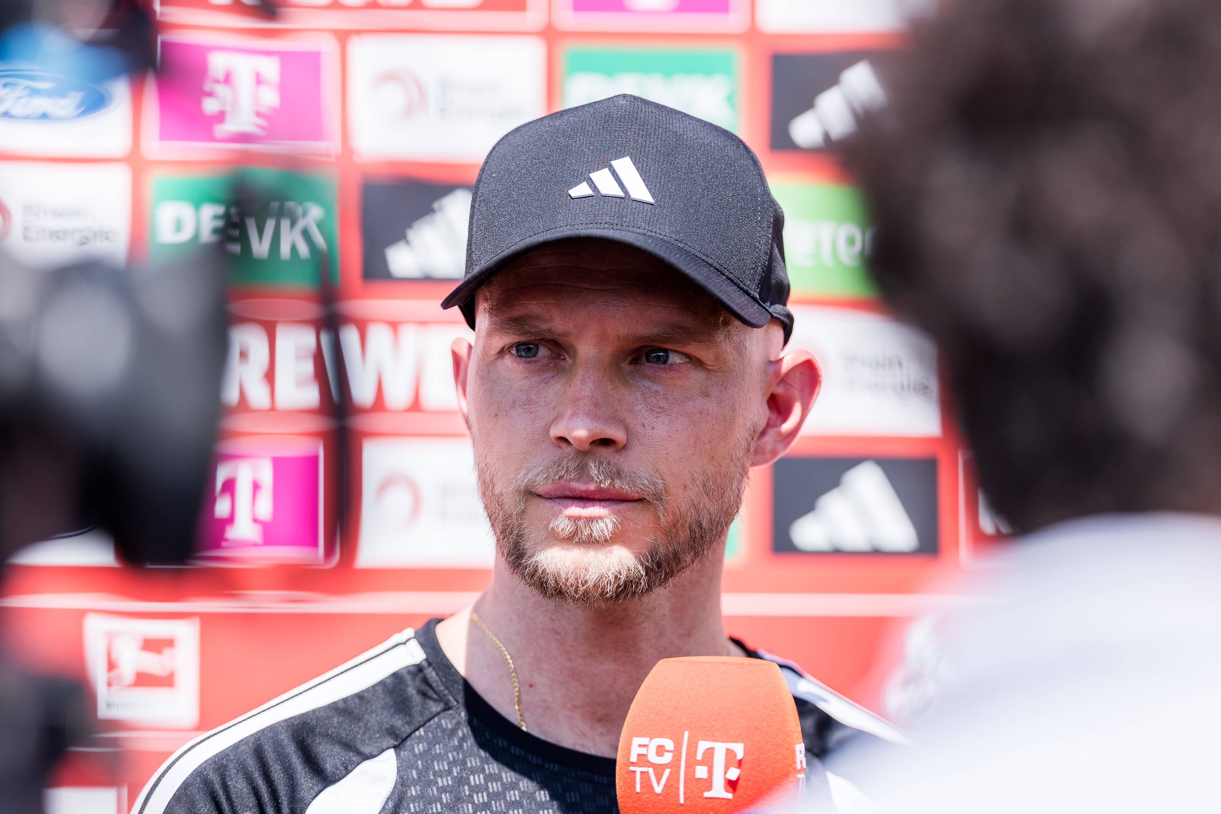 René Wagner steht vor einem FC-Mikrofon.