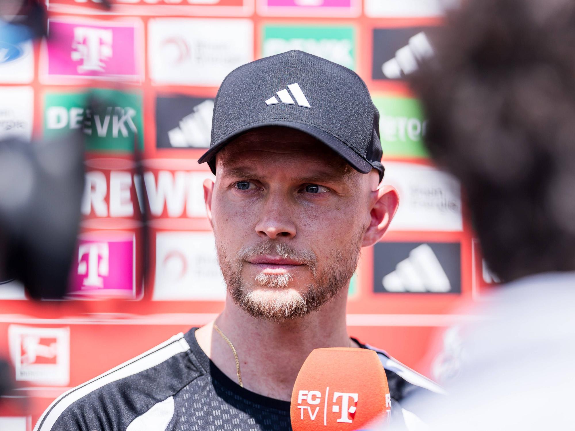 René Wagner steht vor einem FC-Mikrofon.