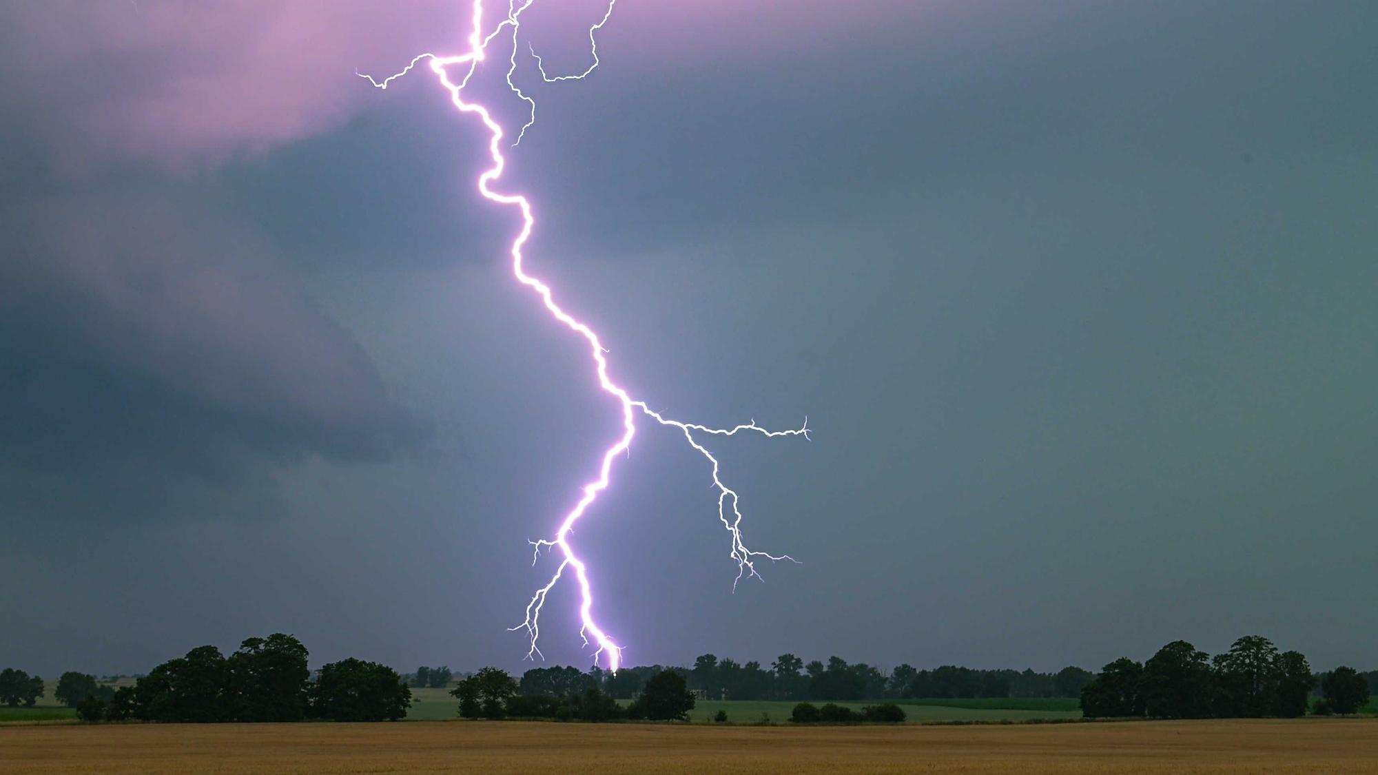 Ein Blitz leuchtet über einer Landschaft auf. (Symbolbild)
