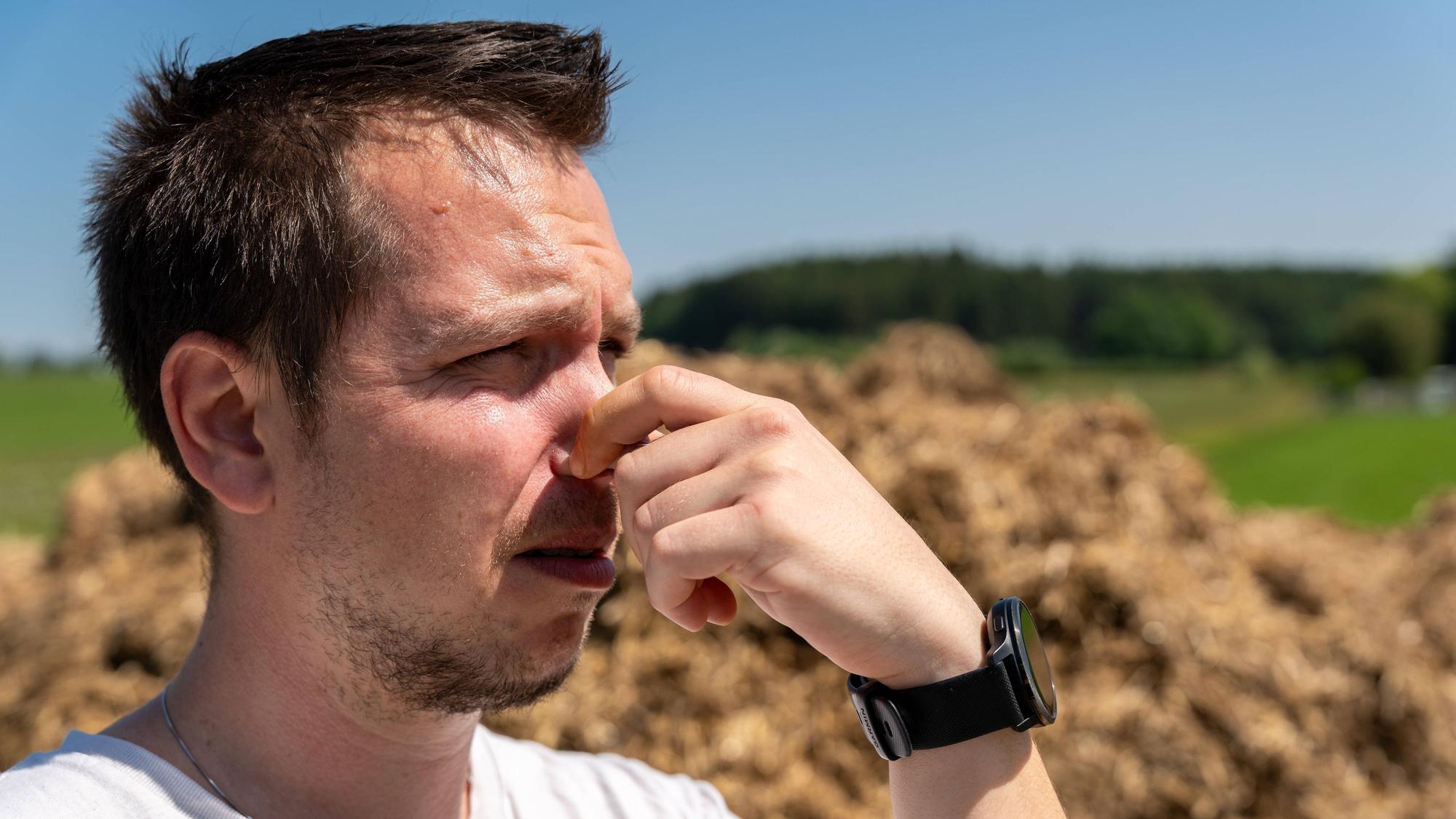 Ein junger Mann hält sich die Nase zu.