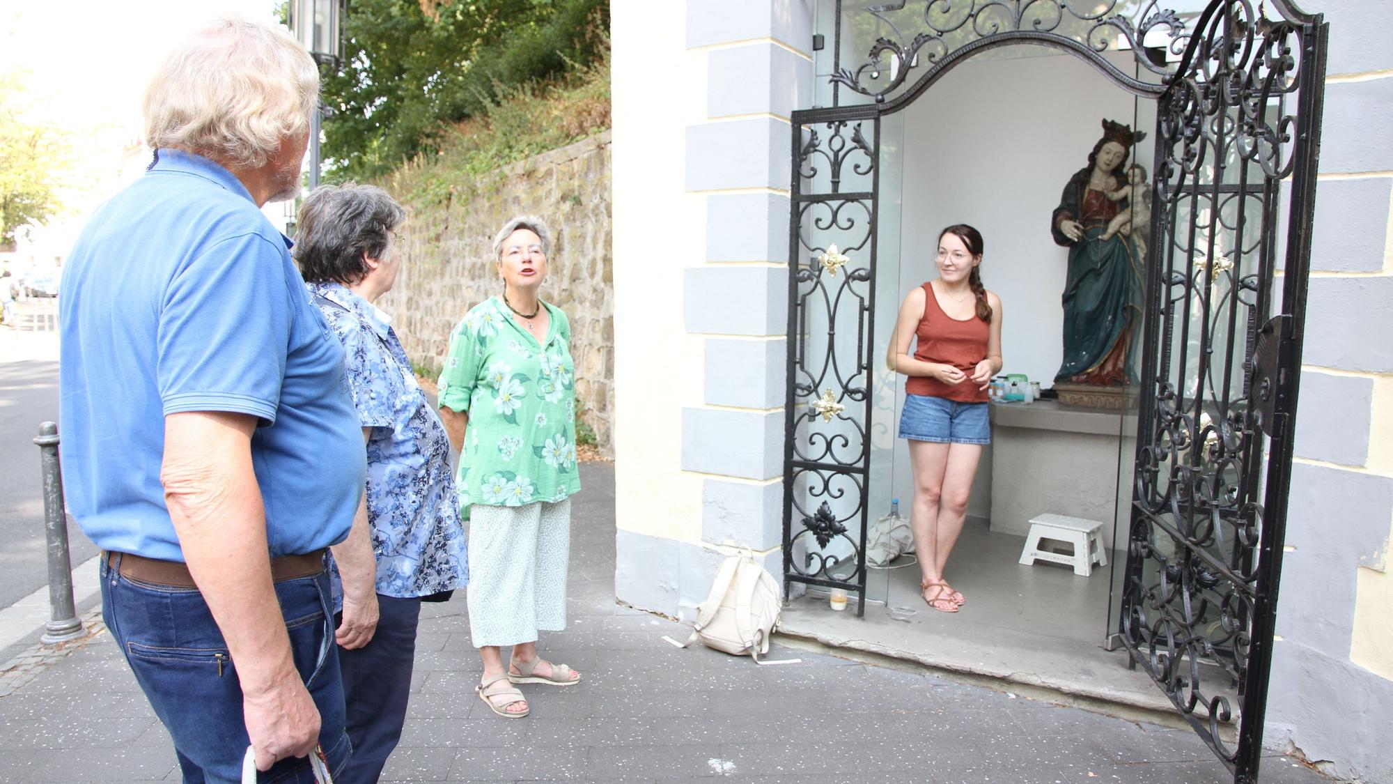 Johanna Baldus (rechts) restauriert die Marienfigur in der kleinen Kapelle an der Siegburger Mühlenstraße, mit Andrea Korte-Böger (2. von rechts)