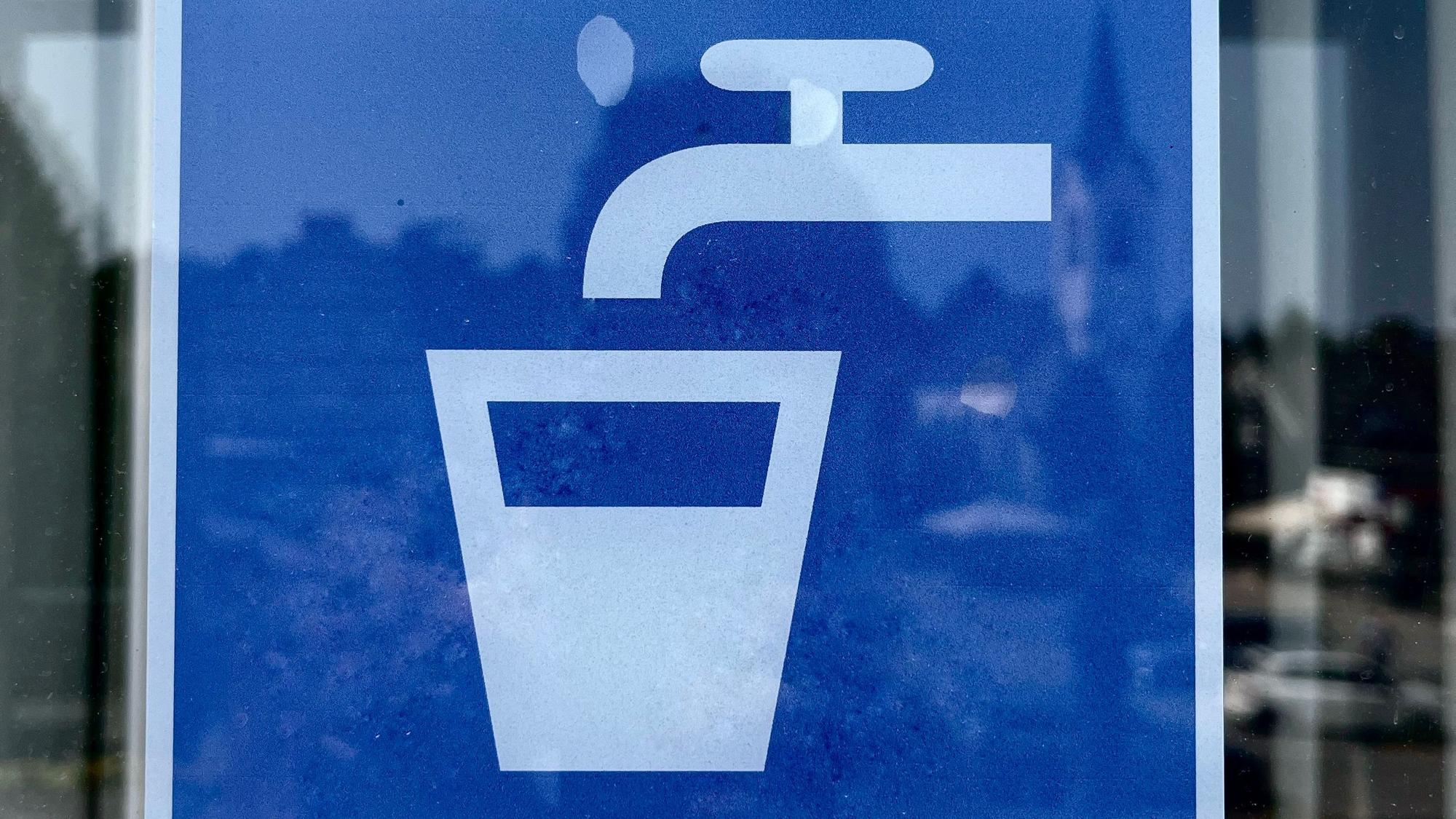 Ein Aufkleber, auf dem steht: „Hier gibt es ein Glas Wasser.“