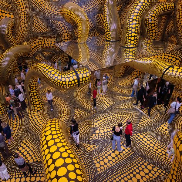 Besucher gehen durch eine Installation mit gelb gepunkteten Tentakeln im Kölner Museum Ludwig.