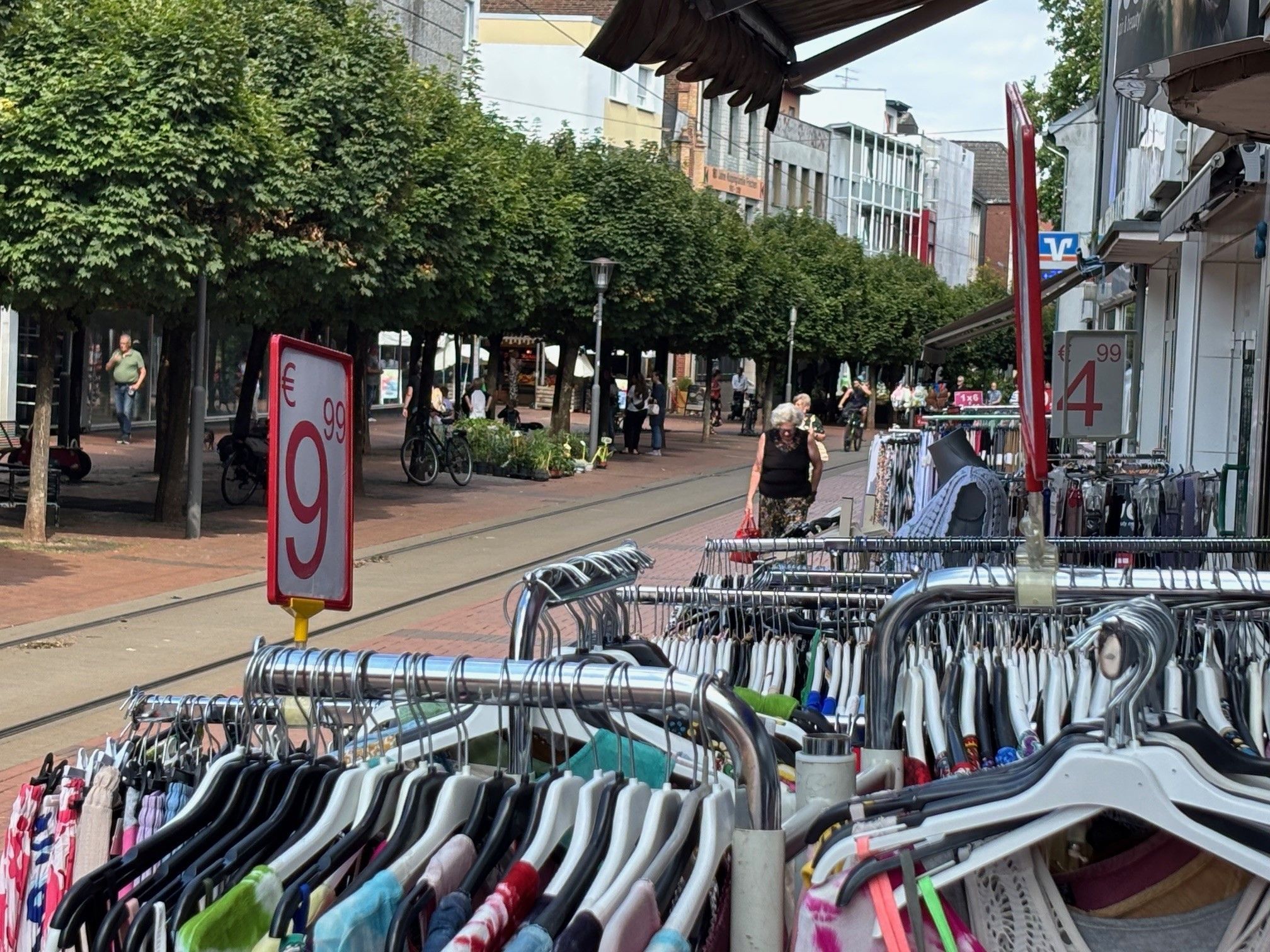 Das Bild zeigt Stände eines Bekleidungsgeschäfts in der Fußgängerzone.